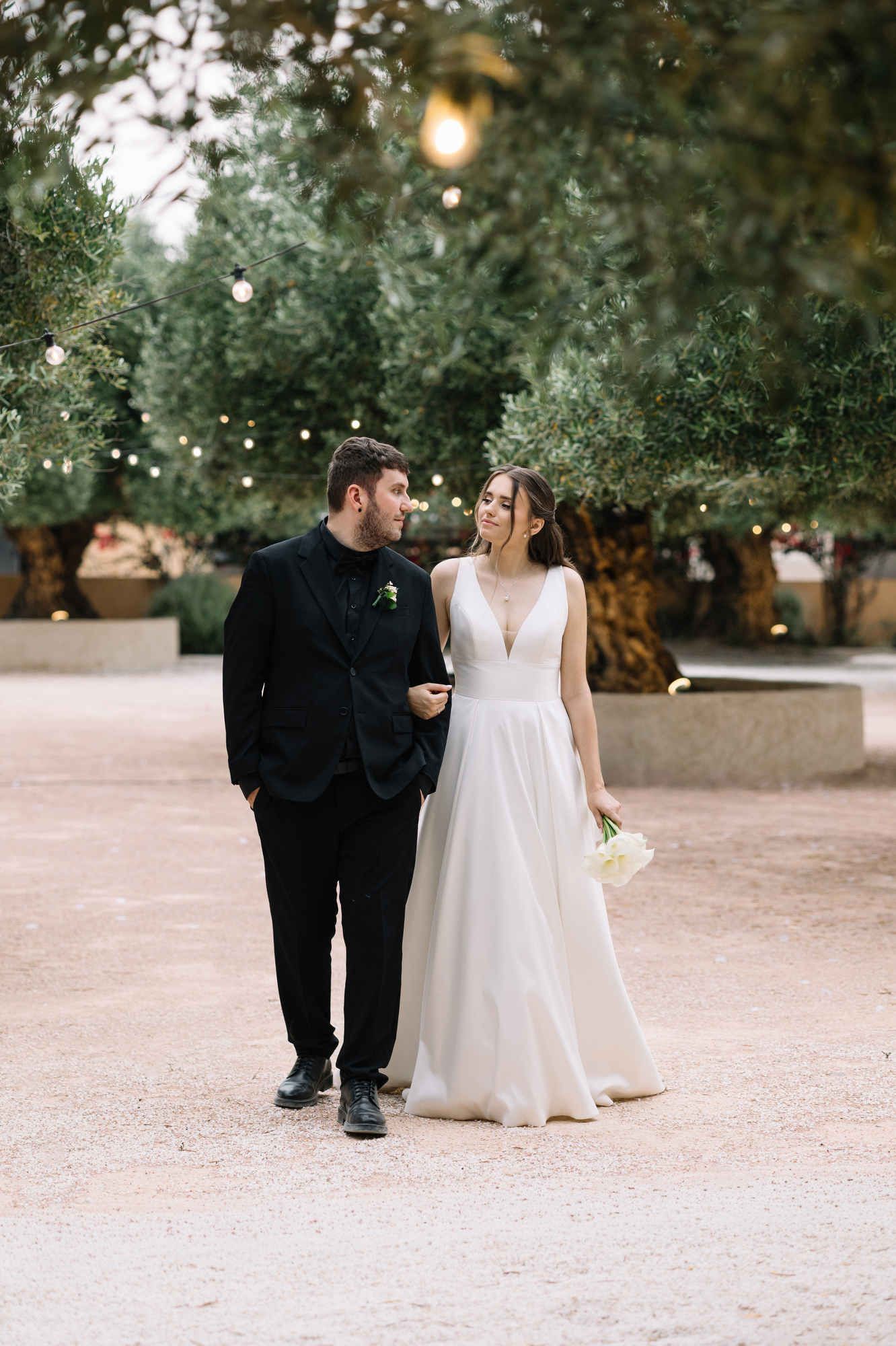 Bride and groom walking through the scenic gardens of Alqueria del Xúquer, enjoying their first moments as a married couple in Valencia.