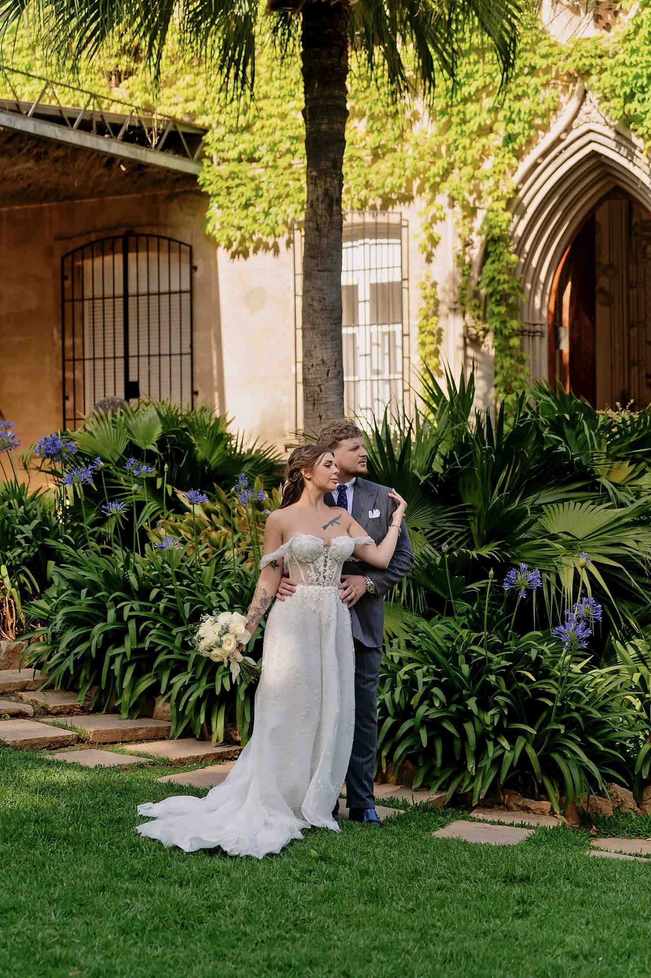 Wide shot of the wedding couple in the historic interior courtyard of Casa Santonja, highlighting the grand scale of the Mediterranean venue