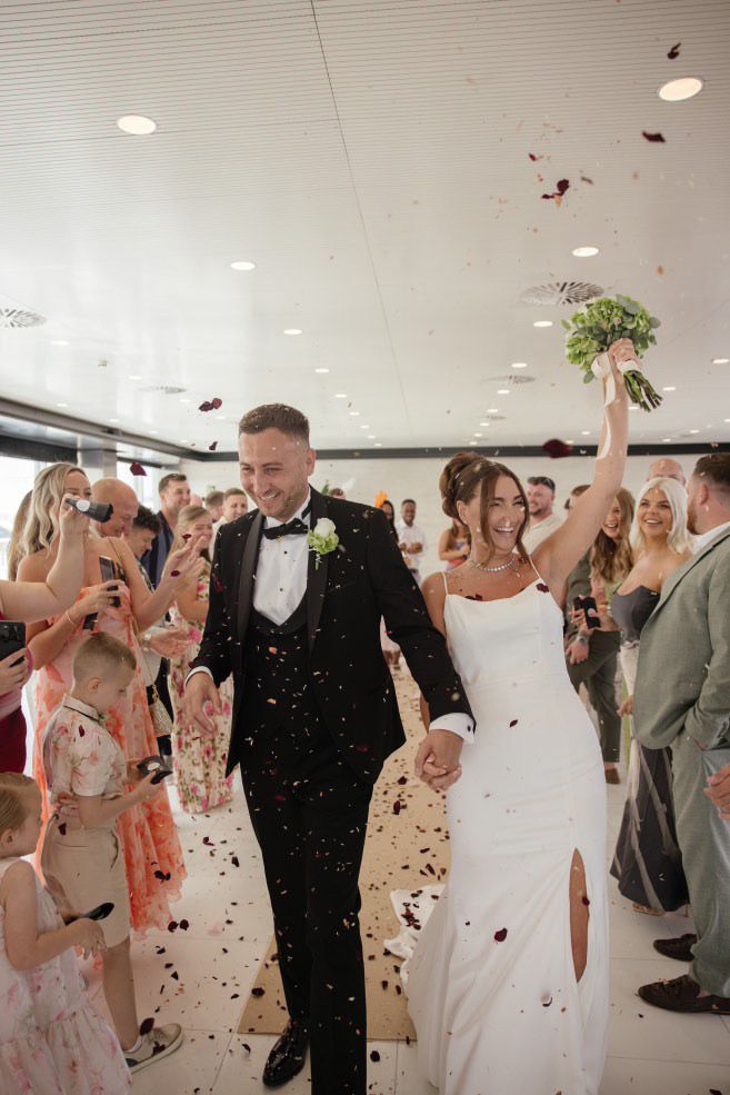 The bride and groom walking through a guest corridor with cold sparks during their wedding celebration at Las Arenas