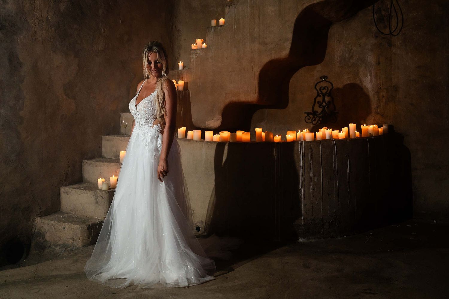 Full-length portrait of the bride surrounded by candles inside the historic Casa Santonja manor, showcasing an elegant wedding gown.