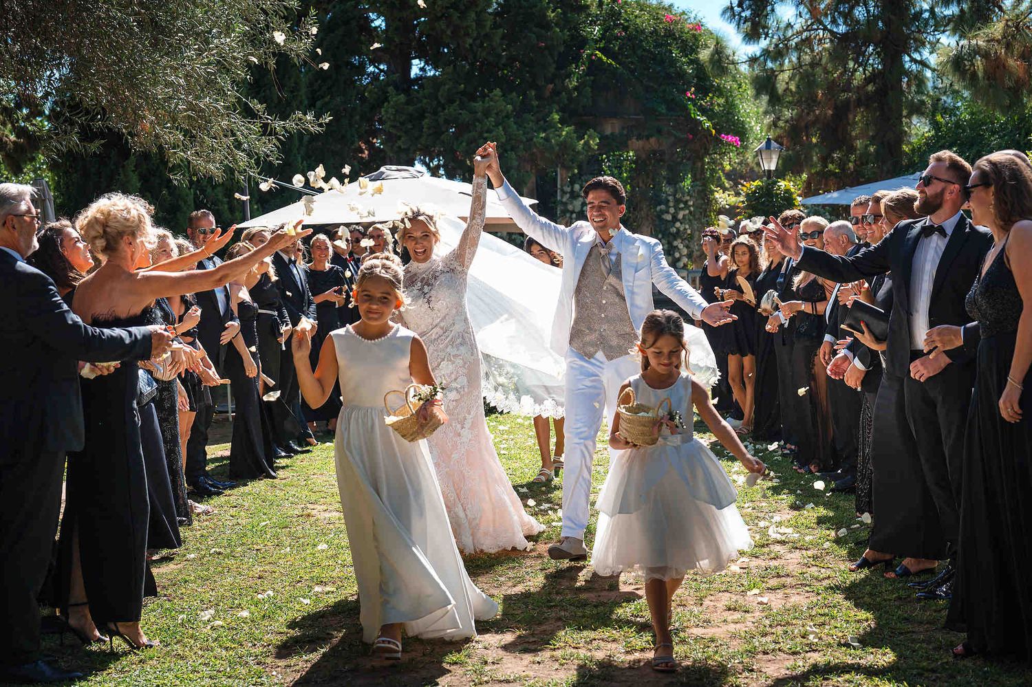 The joyful bride and groom walking through a corridor of cheering guests after their wedding ceremony in Valencia.