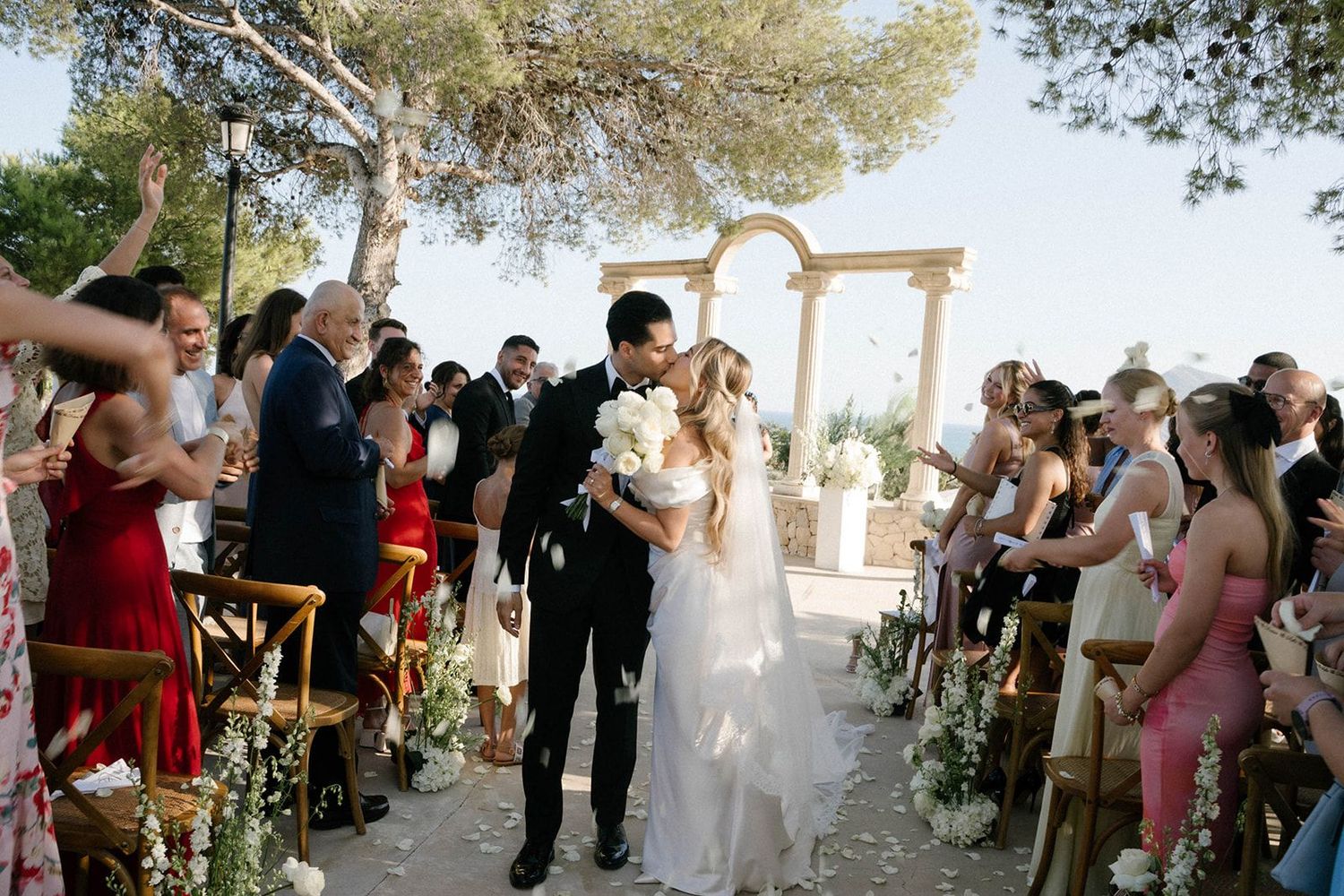 Newlyweds sharing a romantic kiss in the corridor of guests right after the wedding ceremony at Finca Marqués de Montemolar estate, Altea.