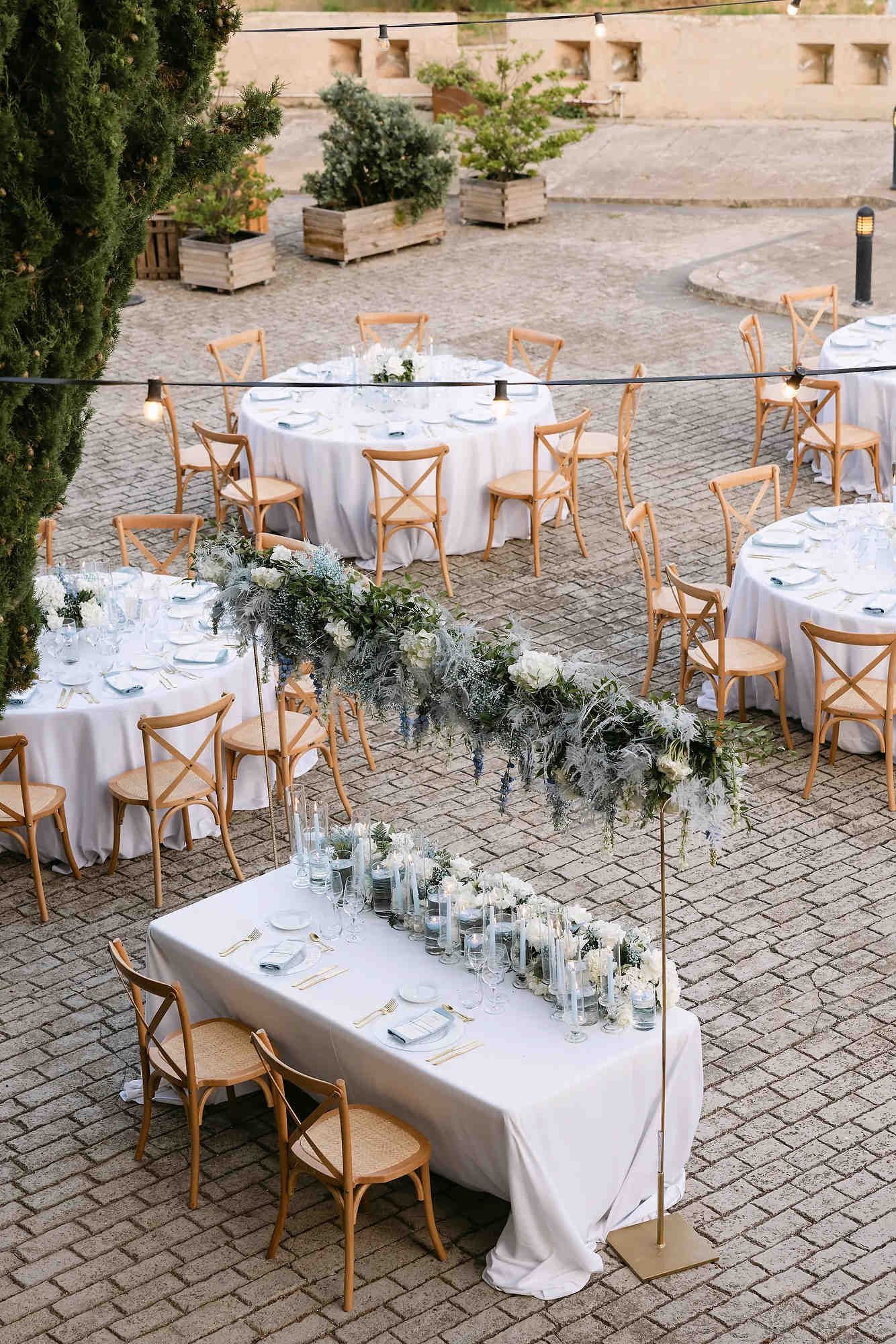 Top view of trendy round banquet tables with luxury floral arrangements and professional wedding decor in Barcelona.