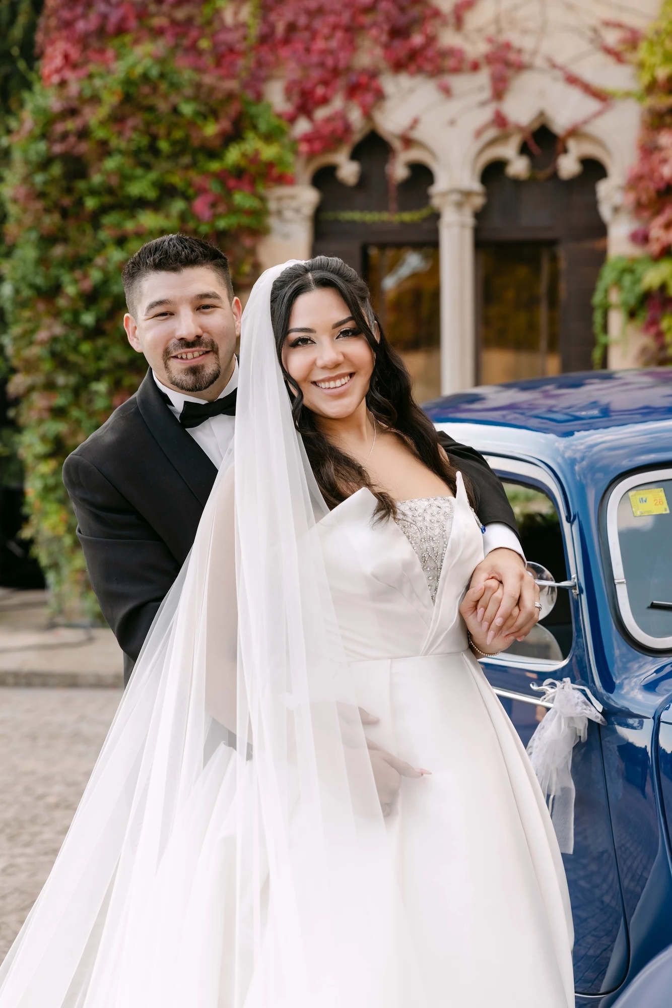 The bride and groom looking into the camera at Castell Jalpí, highlighting the polished bridal hair and makeup look for a Barcelona wedding.