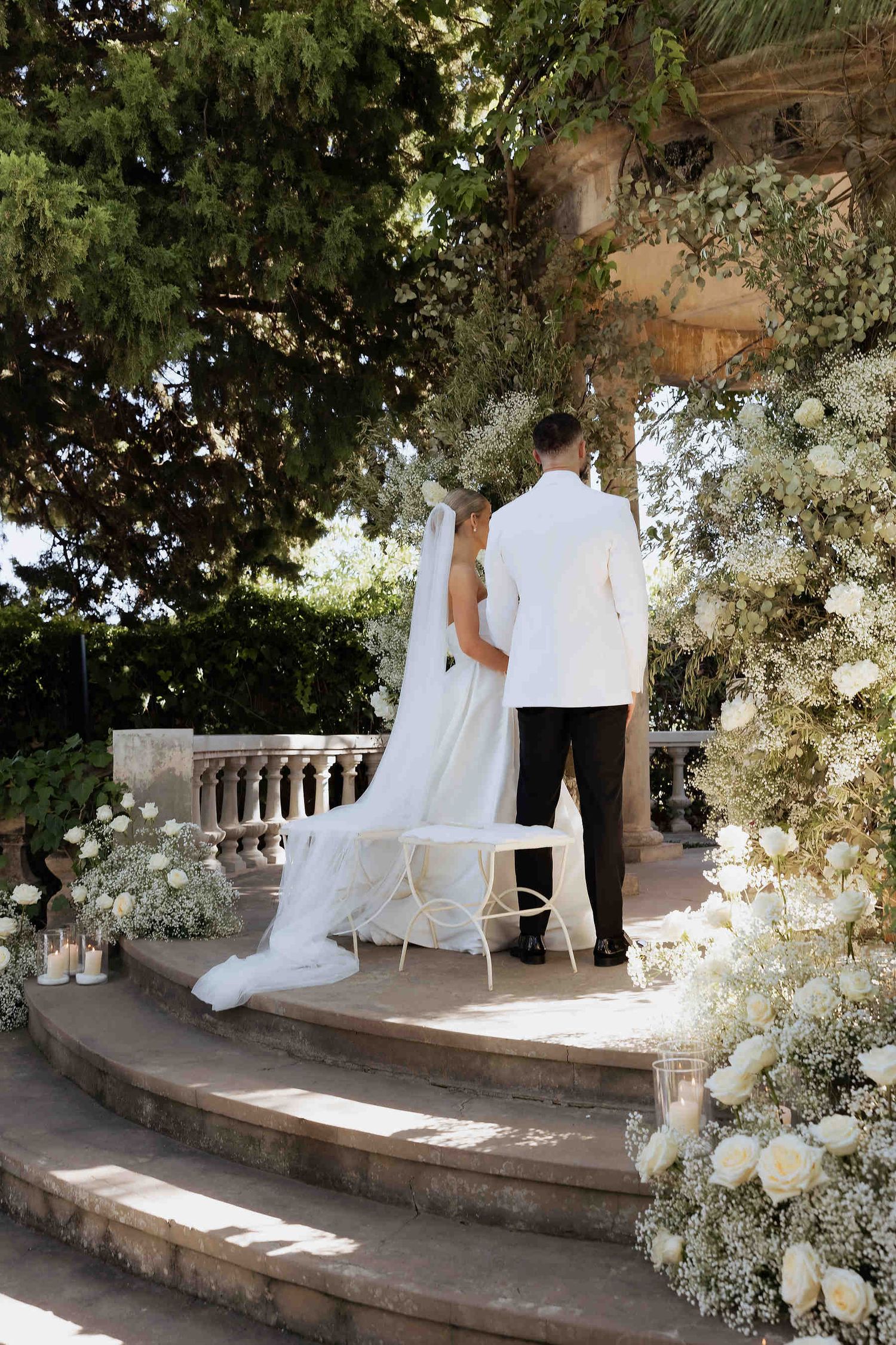 Romantic wedding couple portrait taken under the ancient trees of Casa Santonja, capturing the essence of a garden celebration.