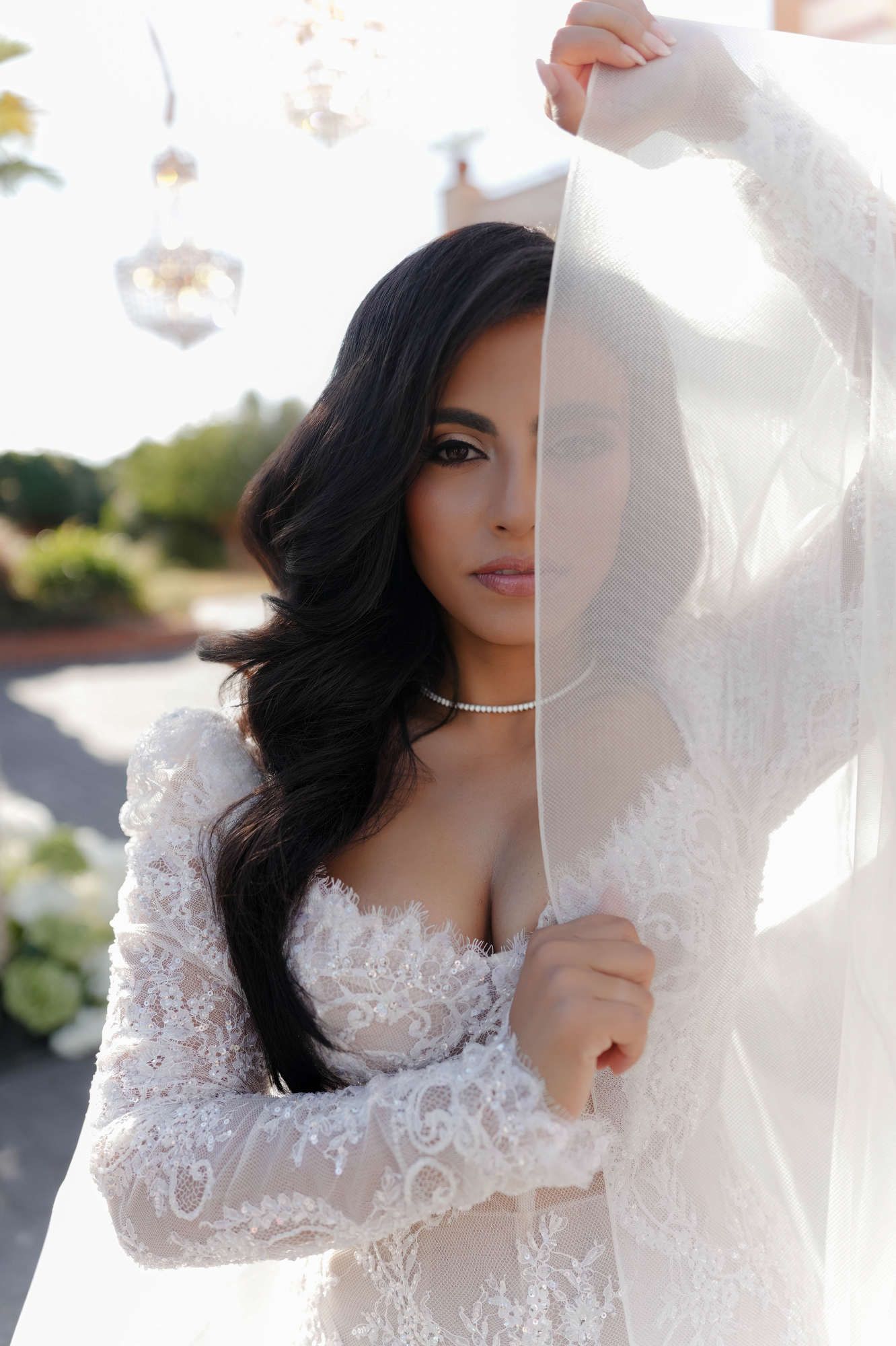 Brunette bride posing with a long veil and voluminous Hollywood waves, featuring professional makeup at Gran Villa Rosa