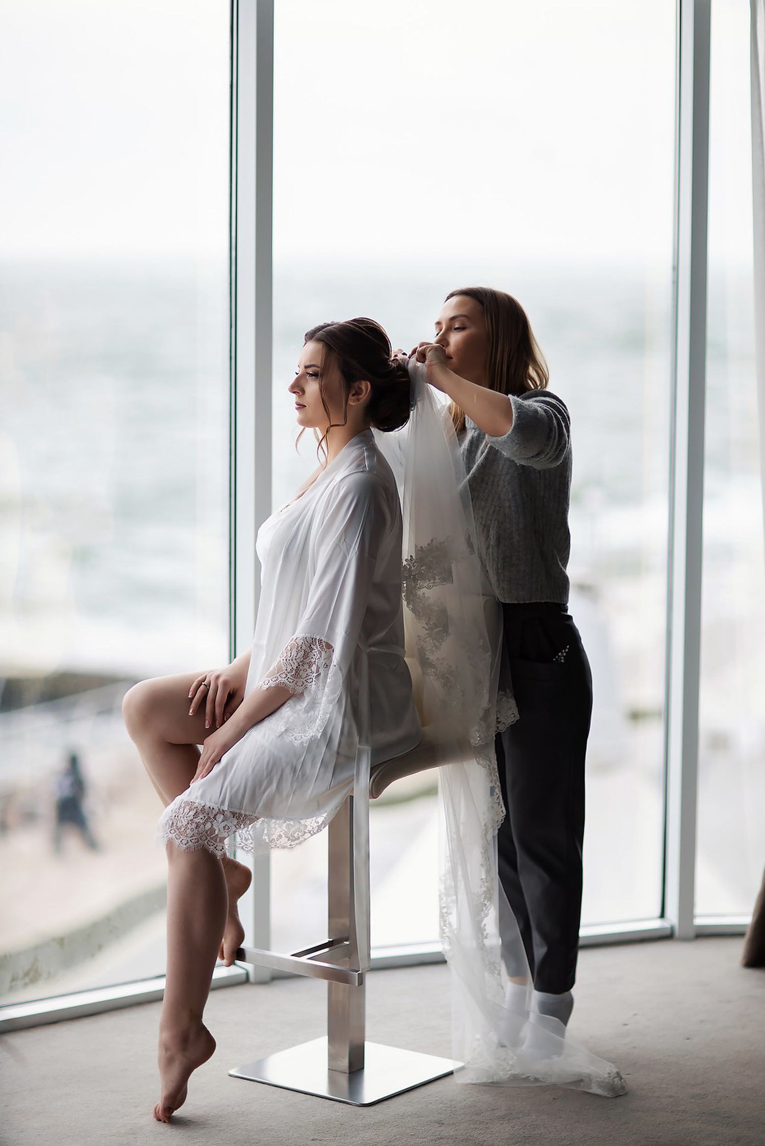 Professional stylist Anastasia Larionova perfecting the bride's hairstyle during the morning preparations for a wedding in Spain.