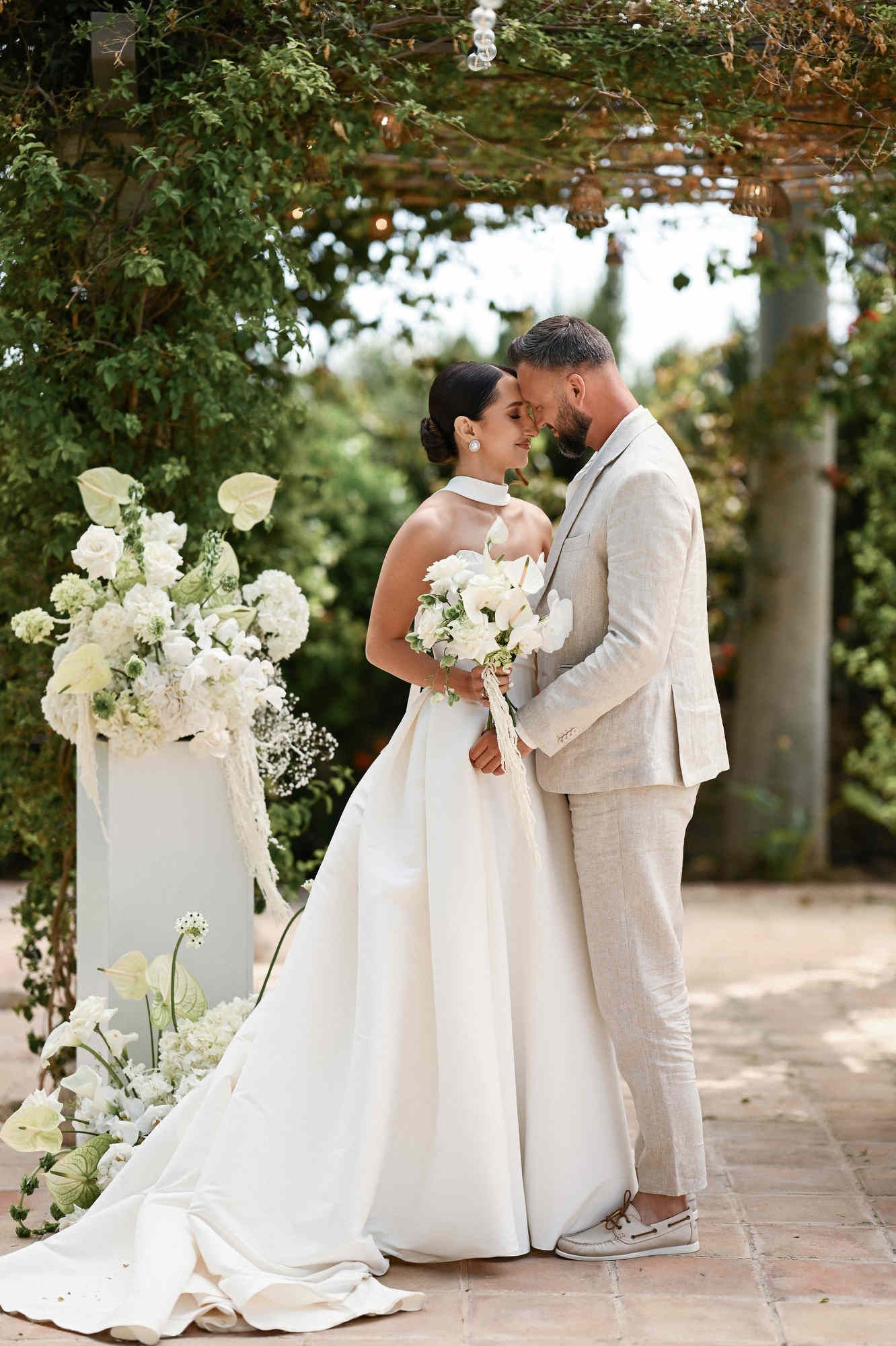 Groom hugging and kissing the bride during a touching, romantic wedding ceremony moment at the outdoor altar of Villa Paula Spain.
