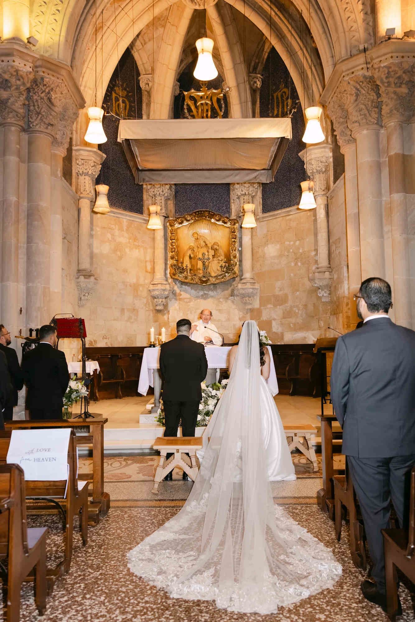 The sacred wedding ceremony of the bride and groom inside the historic Sagrada Família cathedral in Barcelona.