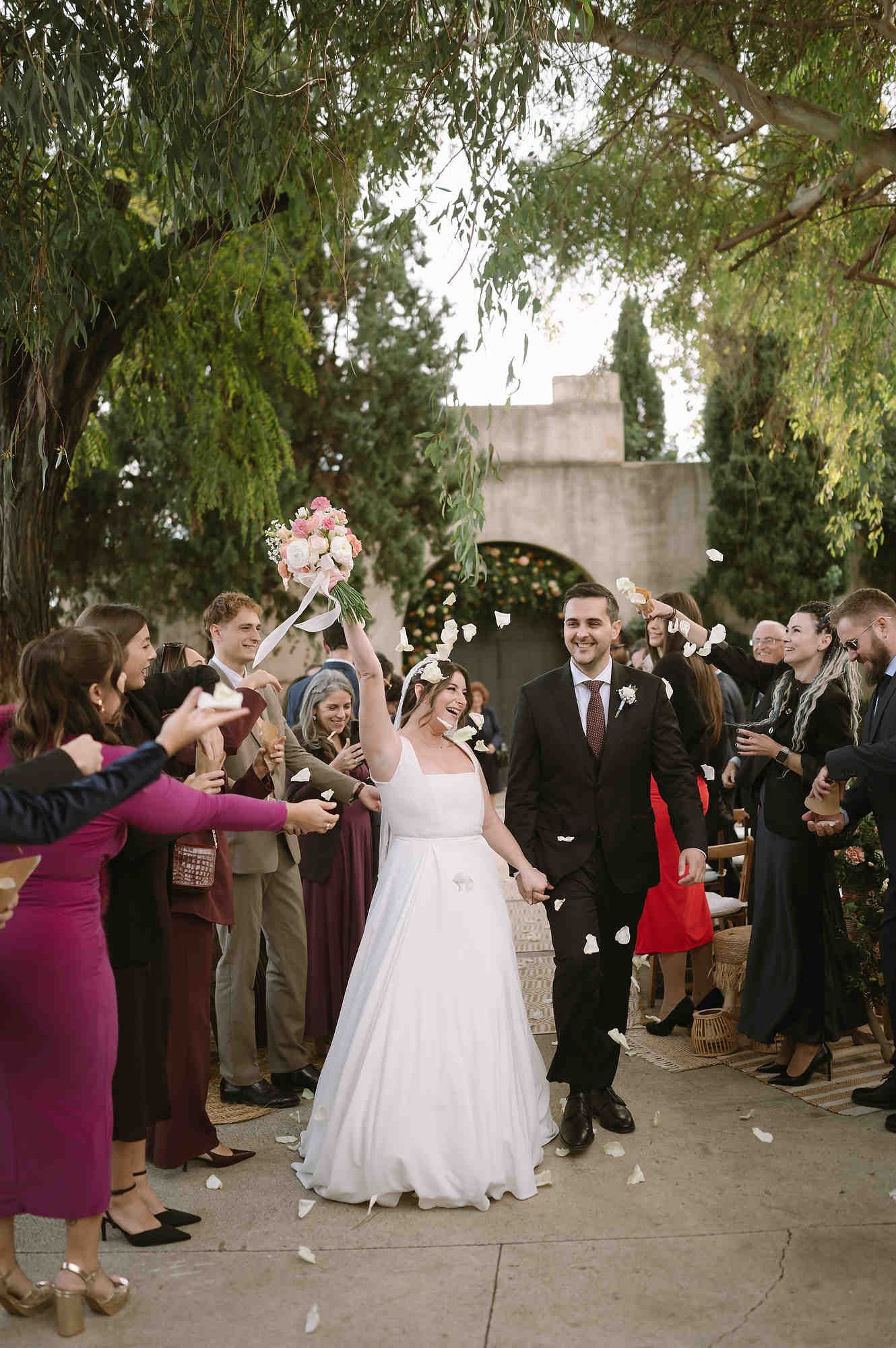 Joyful wedding ceremony exit of the couple at the authentic Mas d’Alzedo venue