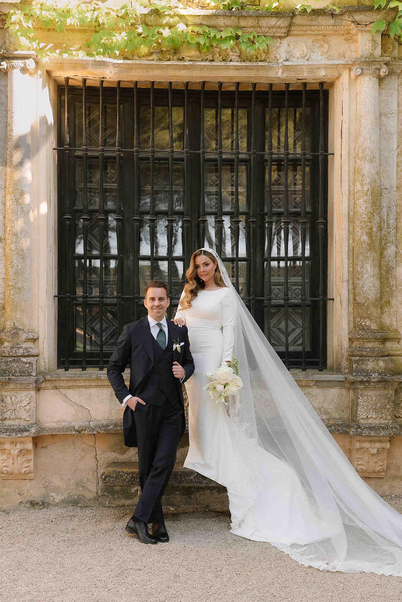 Beautiful bride and groom posing against the noble facade of Finca Torrefiel during their romantic wedding photography session.
