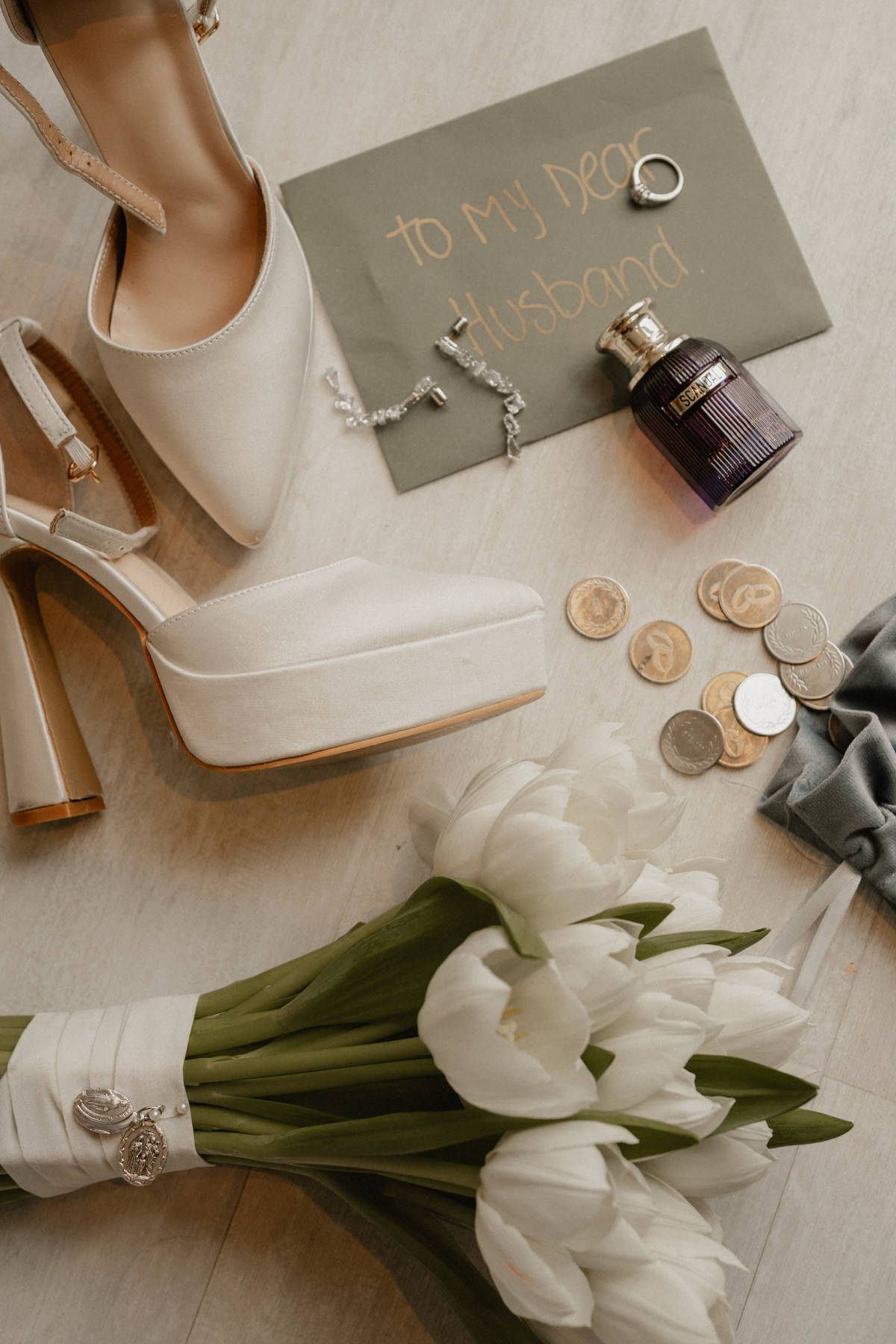 Bridal morning details in the Las Arenas suite, featuring white platform heels, a tulip bouquet, and a letter to her husband.