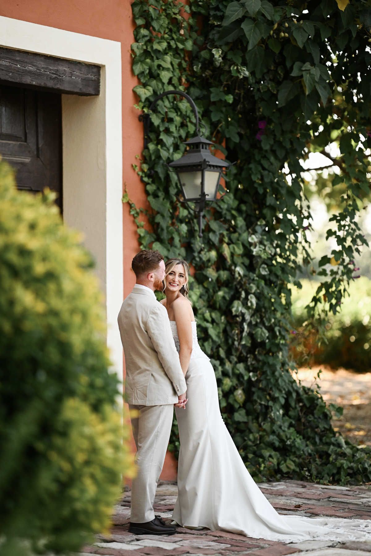 Newlyweds hugging and posing by the historic gates of Villa Delia. Elegant outdoor wedding portrait captured by Darista Wedding photographer
