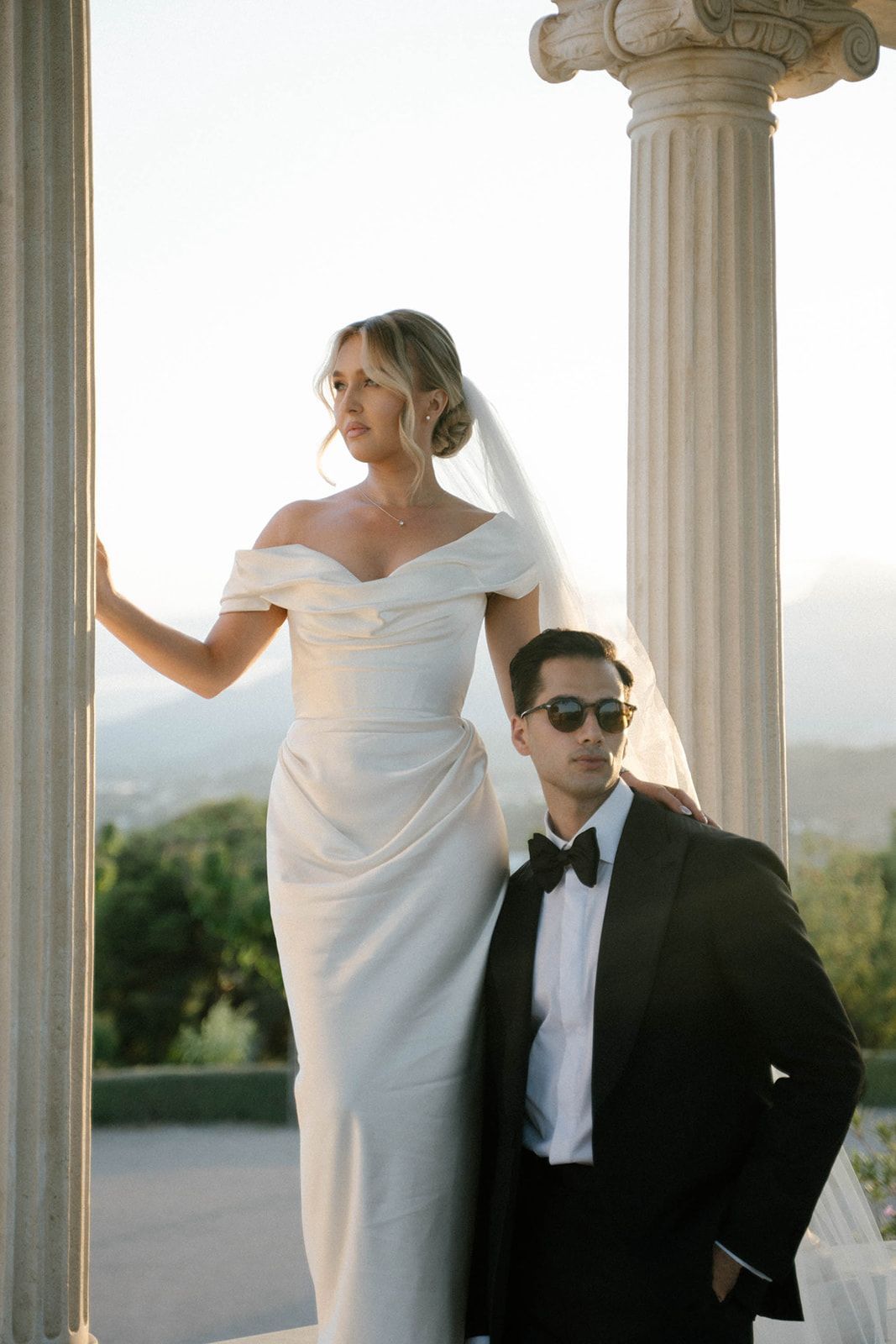 Groom and bride posing for their wedding photographer against a Mediterranean sunset at Finca Marqués de Montemolar in Altea, Spain.