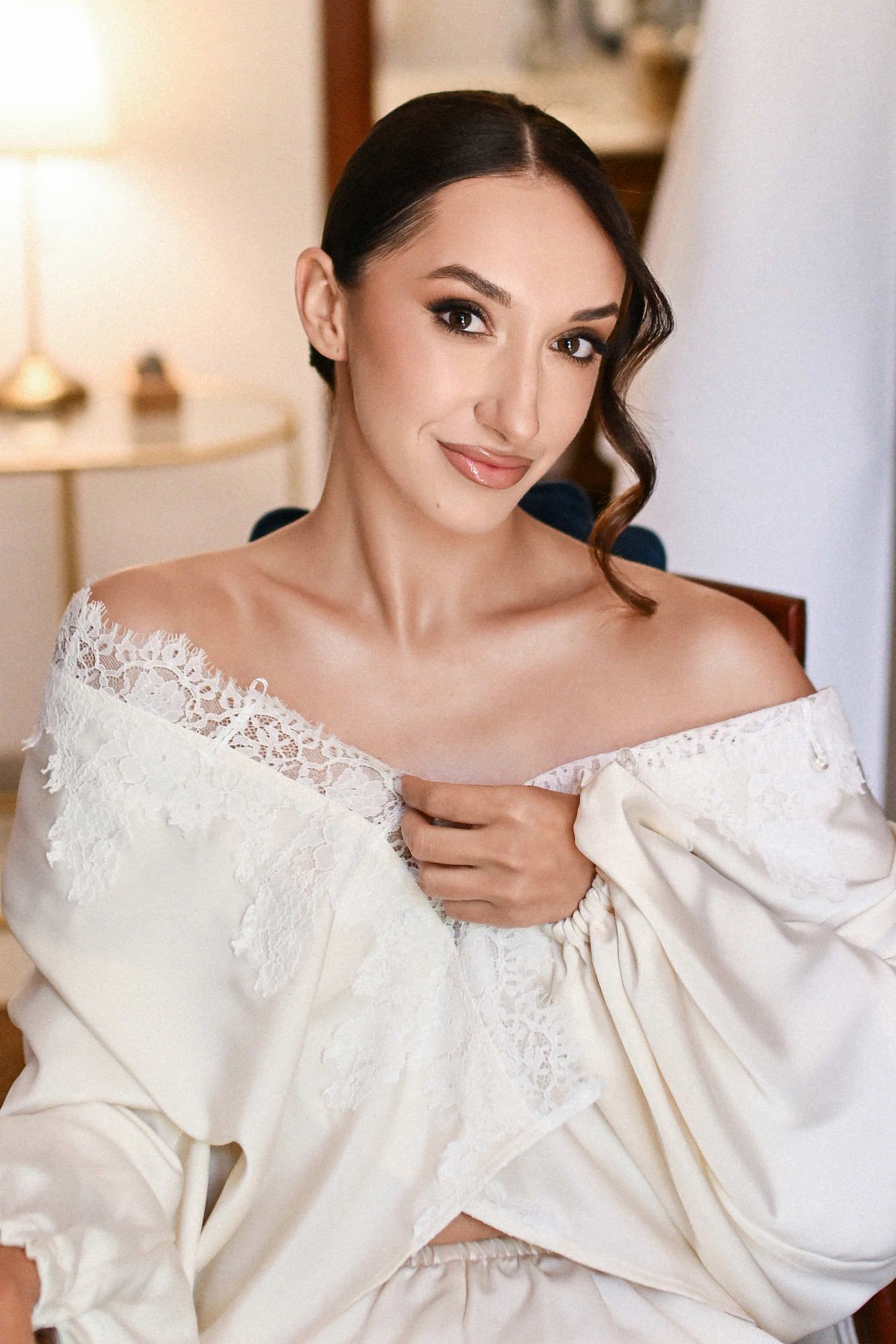 Bride in a robe with finished makeup and hairstyle by Anastasia Larionova, ready to put on her wedding gown at Villa Paula.