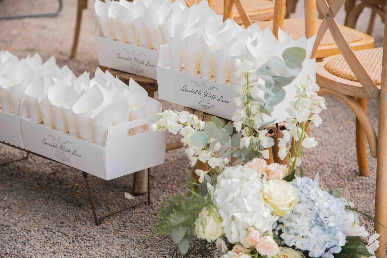 Elegant wedding ceremony decor featuring floral arrangements on the gravel esplanade, set against the iconic neoclassical facade of Huerto S