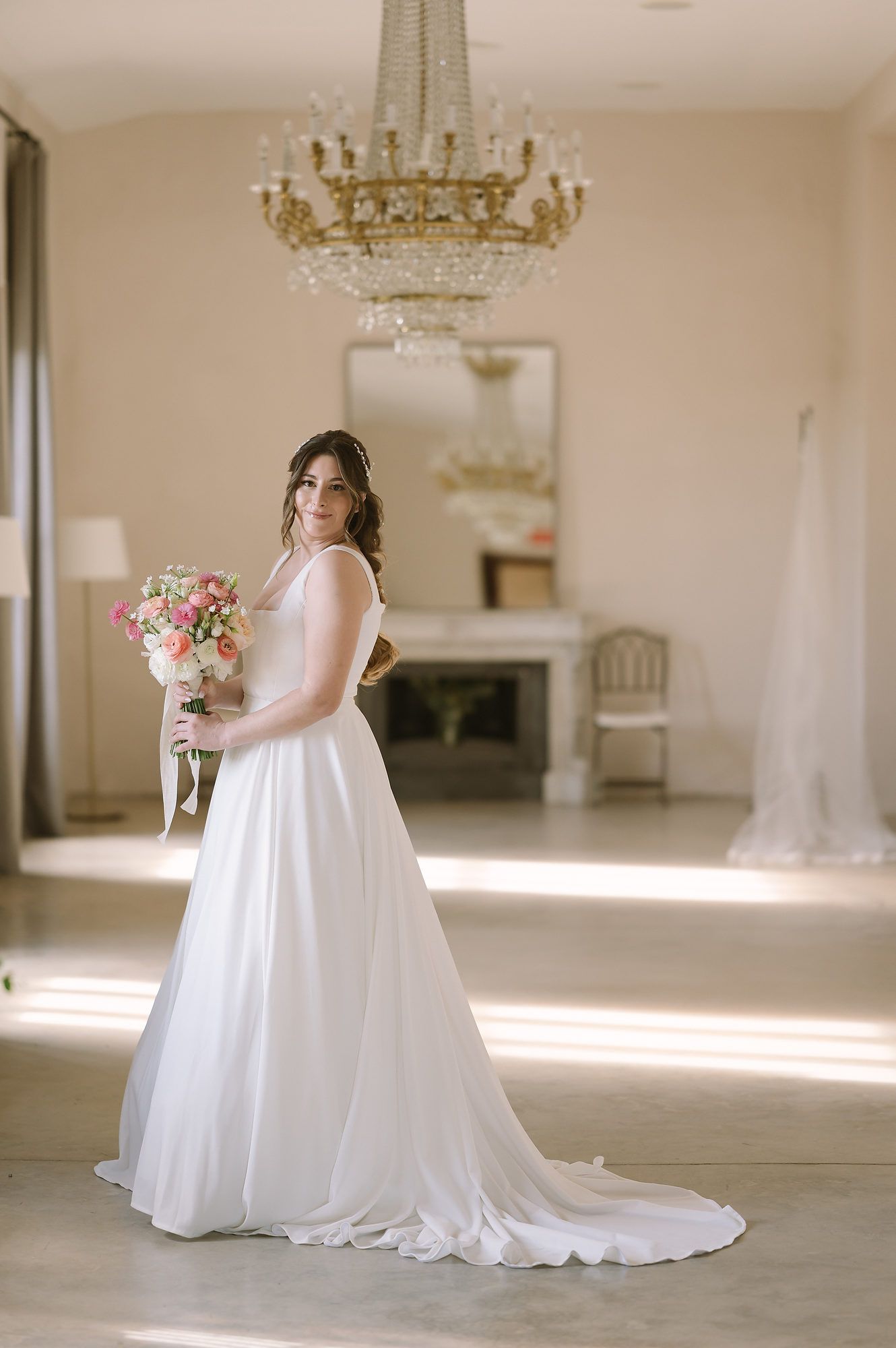 Full-length portrait of a bride in her wedding dress inside the historic halls of Mas d’Alzedo estate