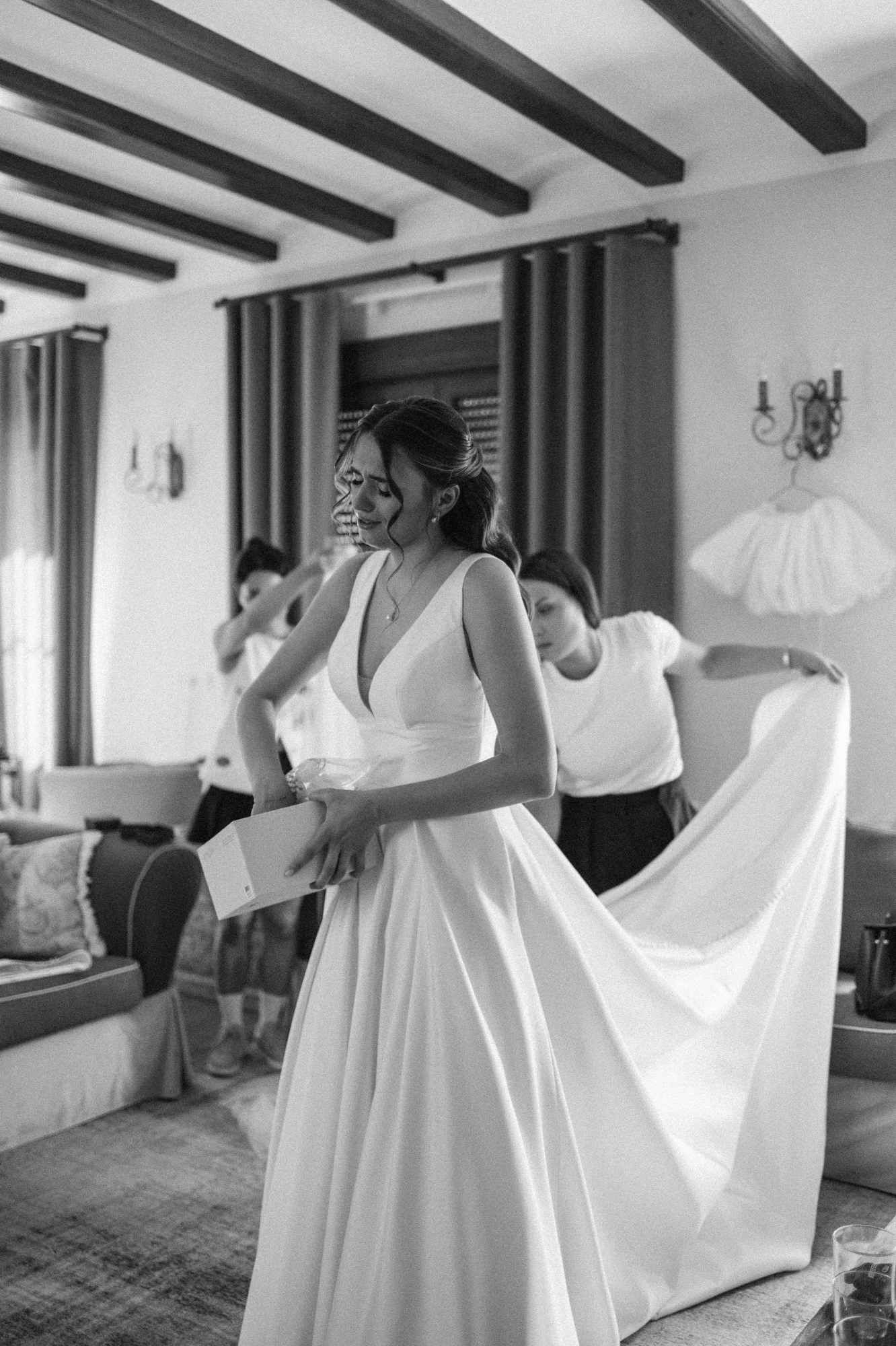 Wedding stylist helping the bride adjust her dress at Alqueria del Xúquer, ensuring every detail is perfect before the garden ceremony.