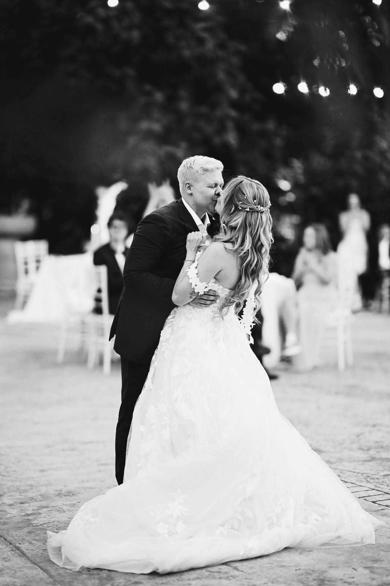 Groom kisses the bride during their romantic first dance in the outdoor courtyard of villa Finca El Senoret in Spain