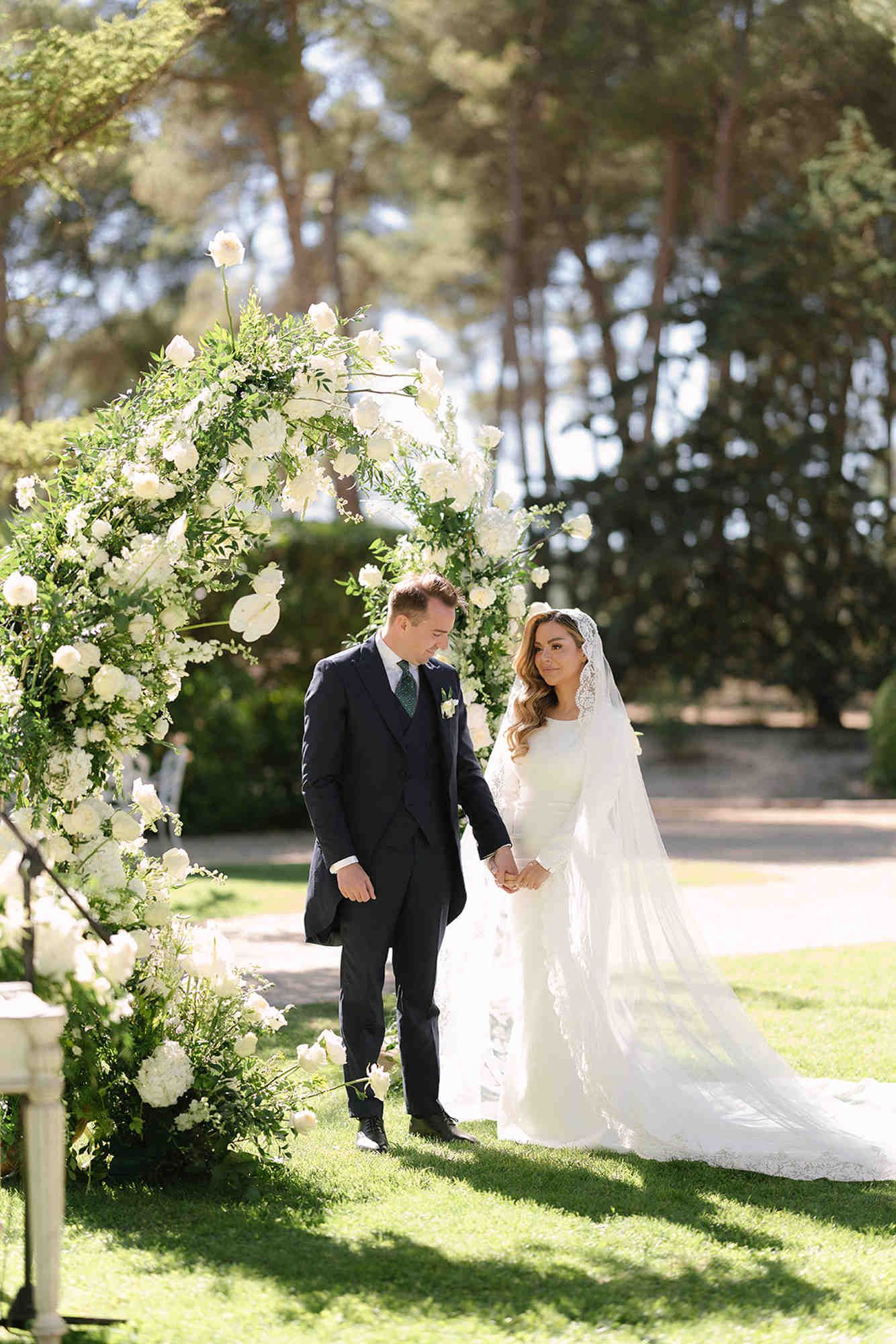 Bride and groom at the altar during their Finca Torrefiel ceremony. Full bridal look with flawless long-lasting makeup and hair.
