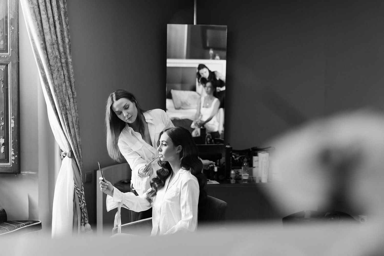 Anastasia Larionova applying bridal lipstick in Barcelona. Professional editorial makeup and hair styling for a luxury wedding look.