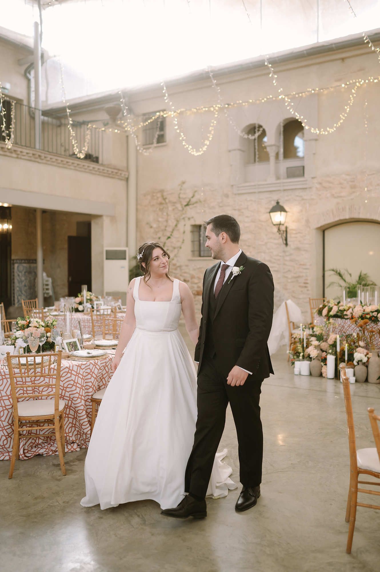 Newlyweds walking at Mas d’Alzedo in Valencia. Featuring professional bridal makeup and hair styling for a luxury wedding.