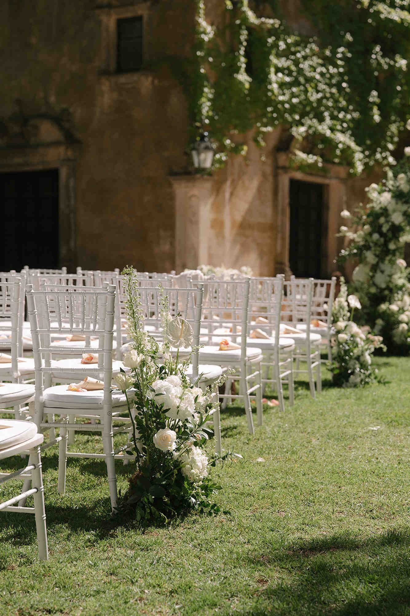 Elegant ceremony chairs adorned with fresh flowers at Finca Torrefiel. Beautiful floral details waiting for the wedding guests.