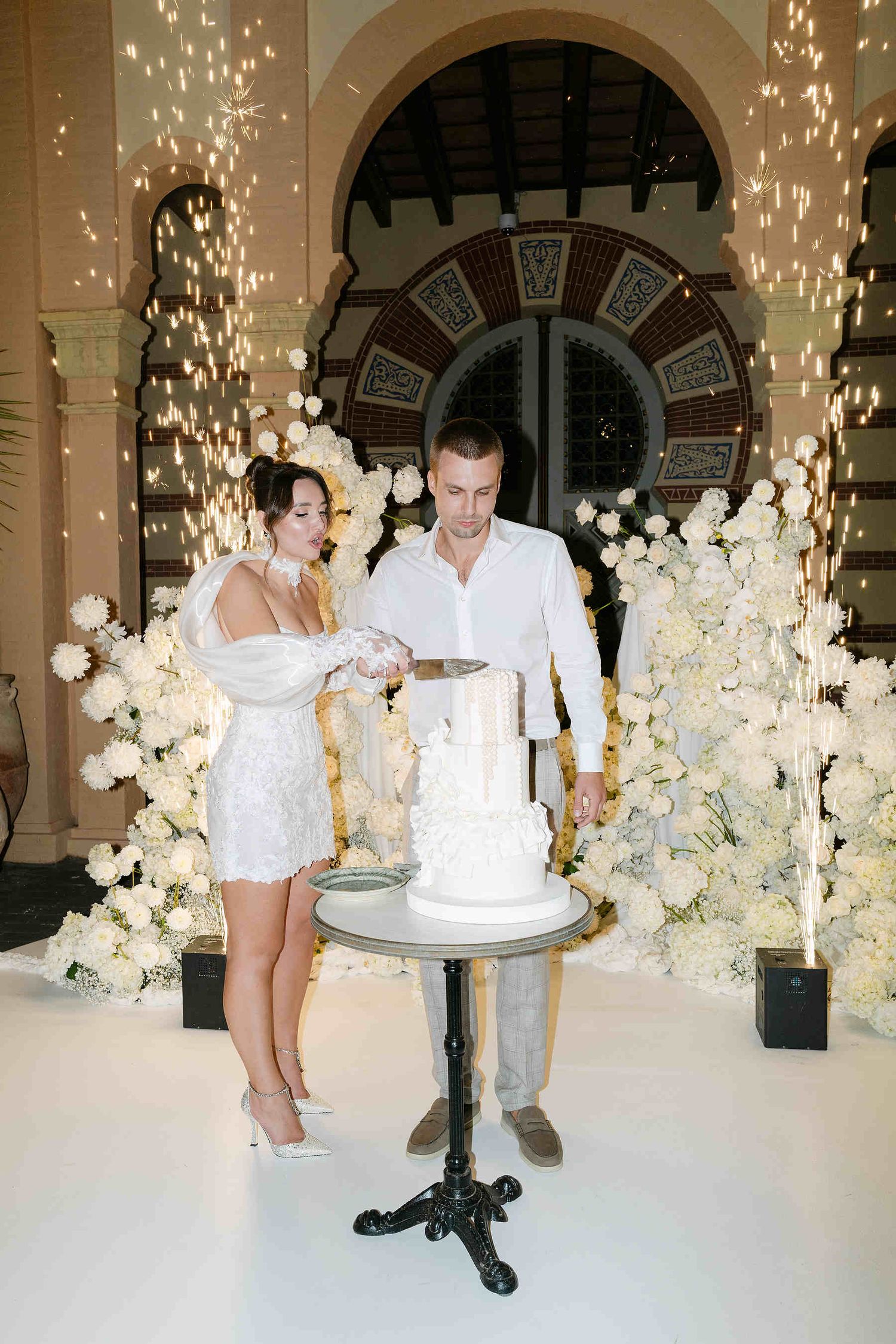 The bride and groom cutting their wedding cake at Gran Villa Rosa, highlighting the evening bridal look and elegant hair styling