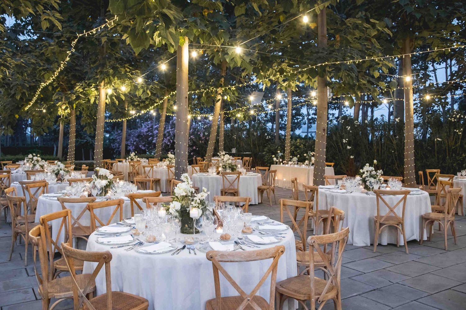 Sophisticated outdoor wedding reception decor with Mediterranean details and table settings in the lush gardens of the Huerto San Rafael est