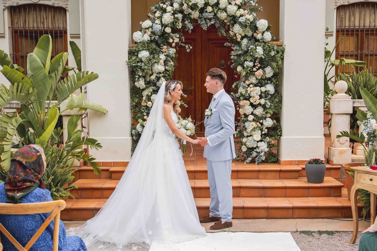 A sophisticated bride posing against the neoclassical facade of Huerto San Rafael, highlighting a timeless bridal aesthetic