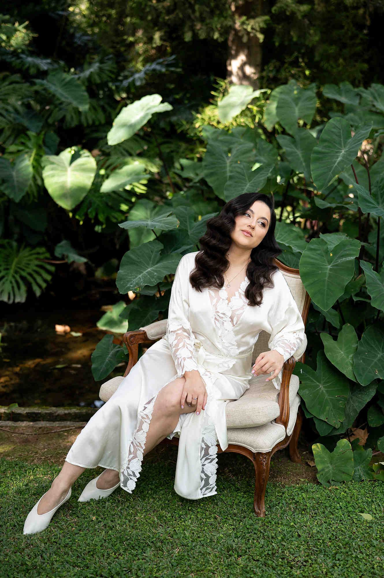 Sophisticated bridal portrait of the bride sitting on a vintage chair in the lush gardens of Casa Santonja