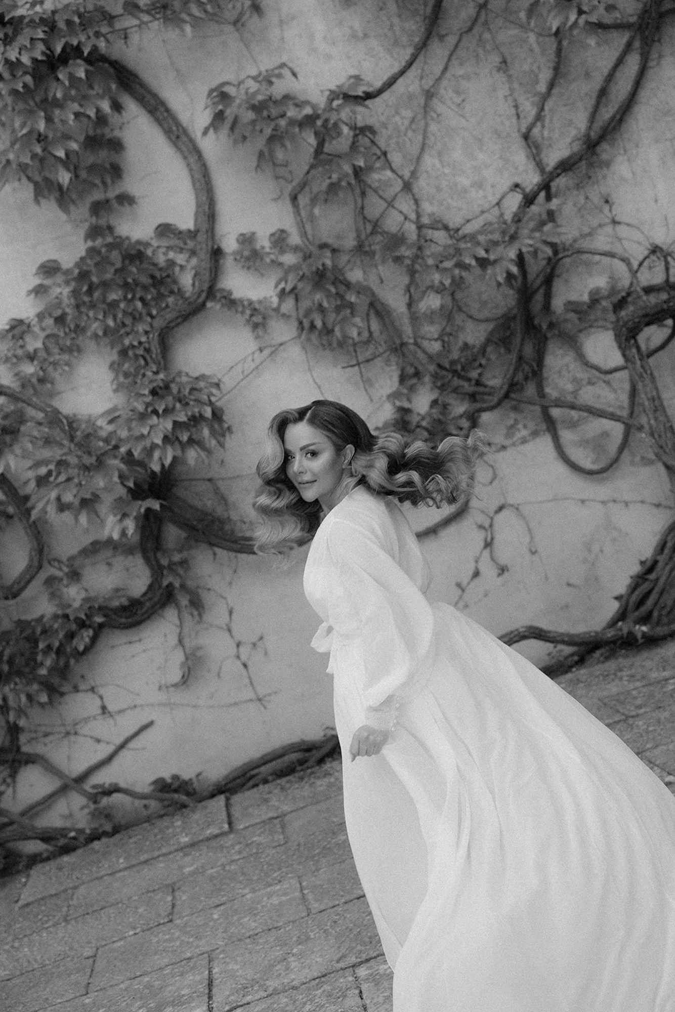 Bride twirling with her long-lasting wedding hairstyle at Finca Torrefiel, showing flawless curls and beautiful hair movement.