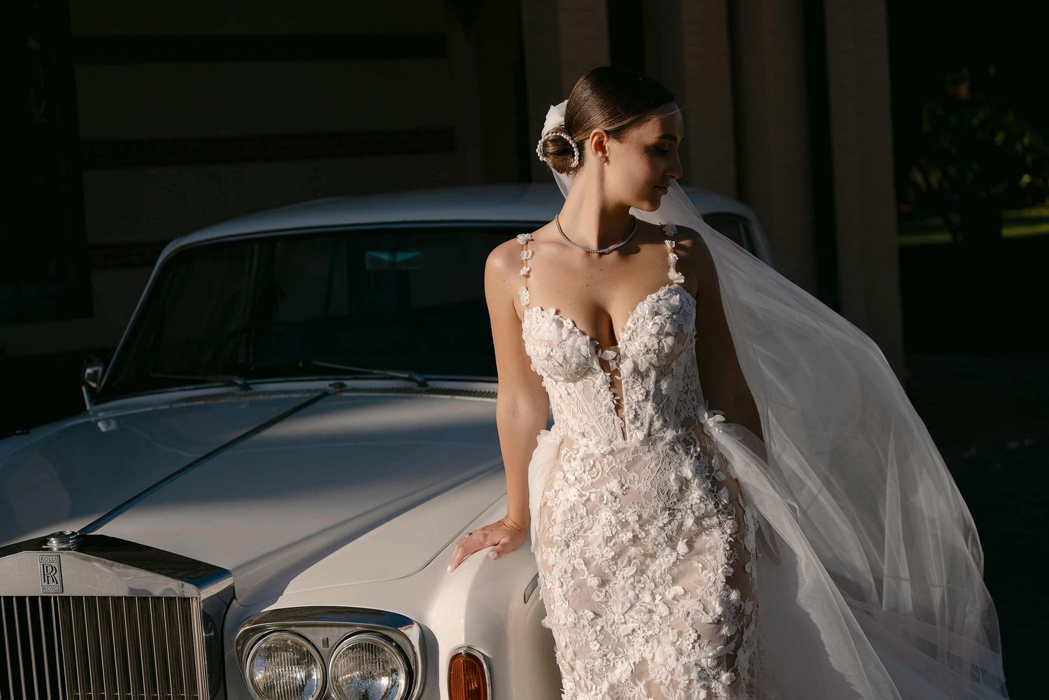 Bride portrait showcasing professional makeup and hair styling with a luxury car and the Gran Villa Rosa villa in the background