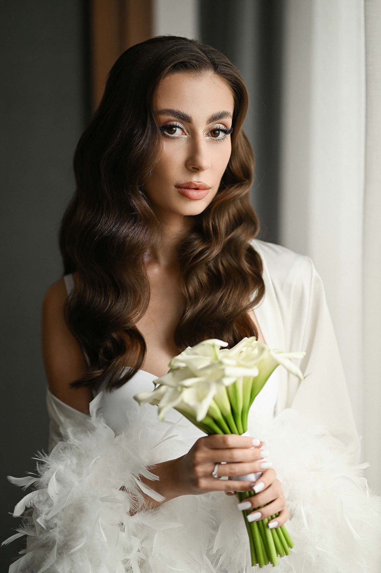 A stunning fashion-inspired bridal look with polished wavy hair and a bouquet at El Telar de Miguel Martí, Valencia.
