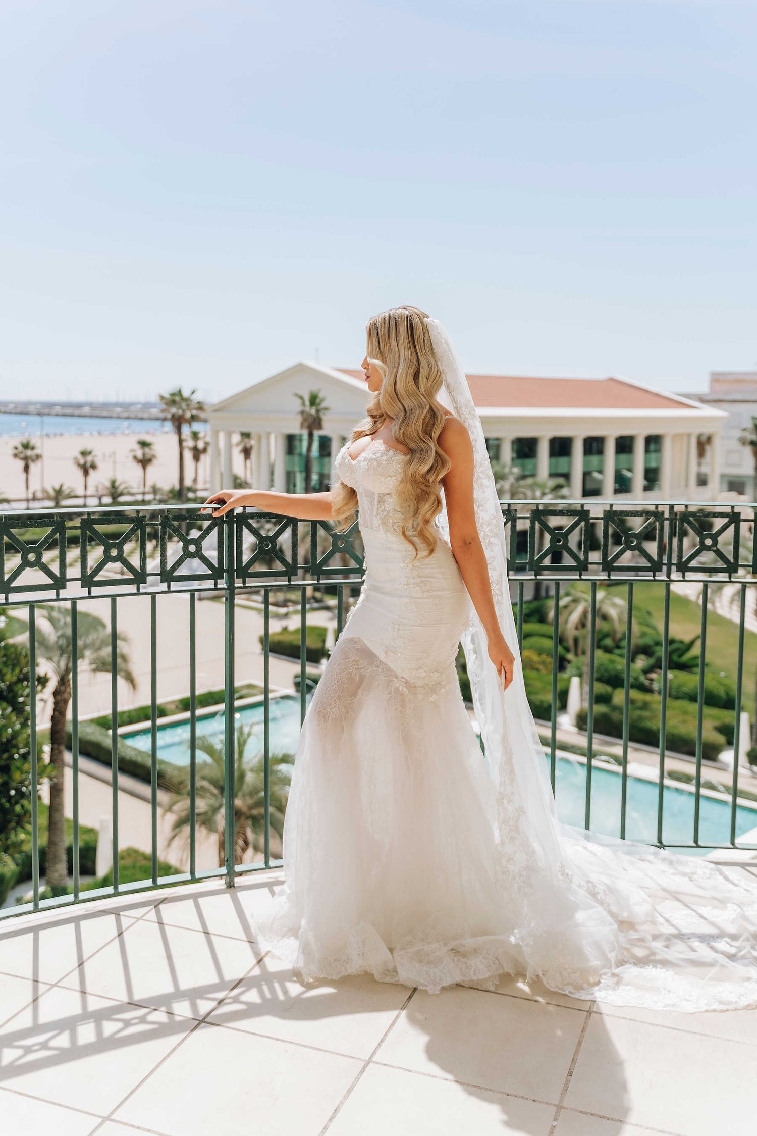 A radiant bride with a polished wedding hairstyle on the terrace of Las Arenas resort overlooking the Malvarrosa beach.