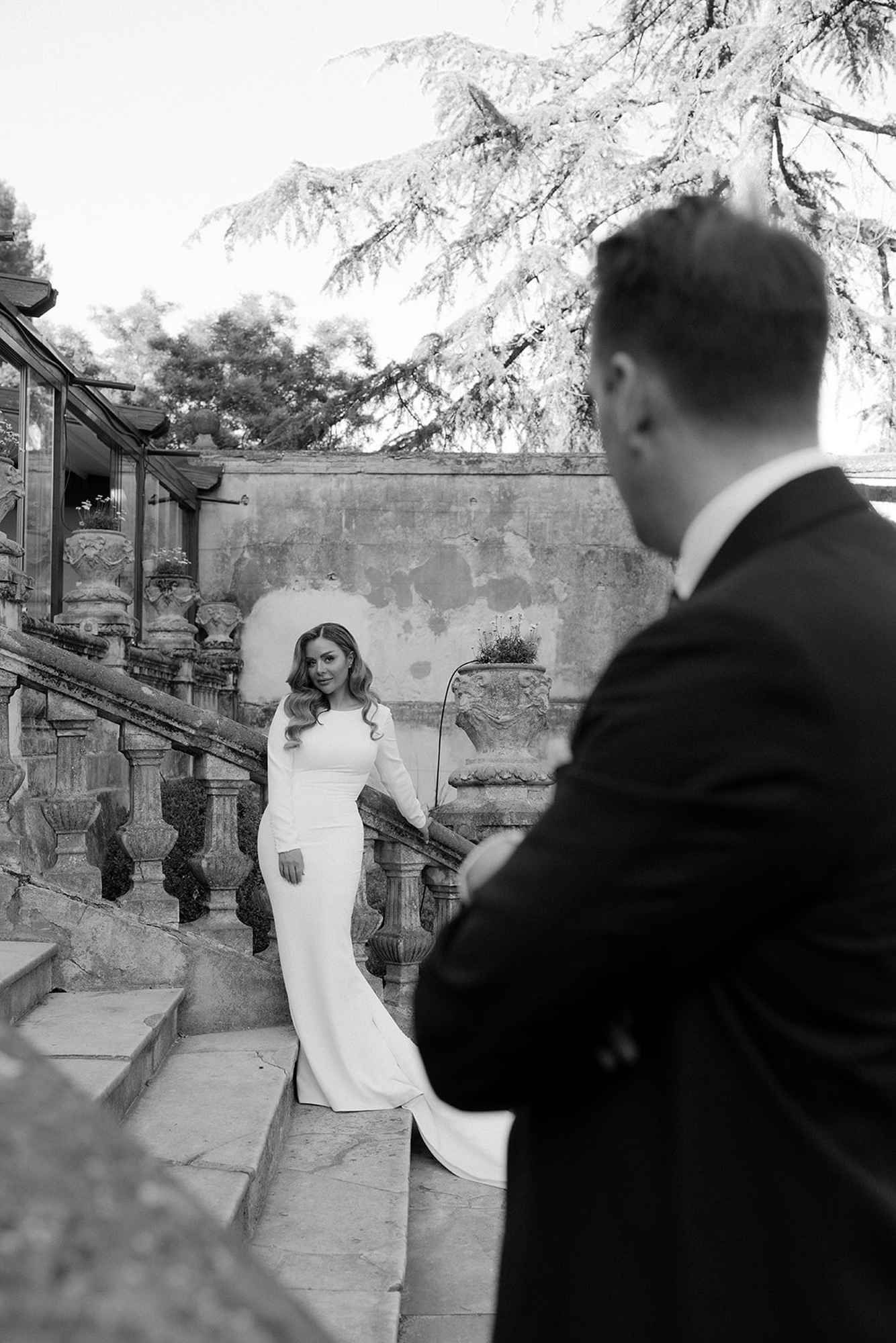 Bride looking at the groom on the historic stone stairs of Finca Torrefiel during an elegant wedding photo shoot in Valencia.