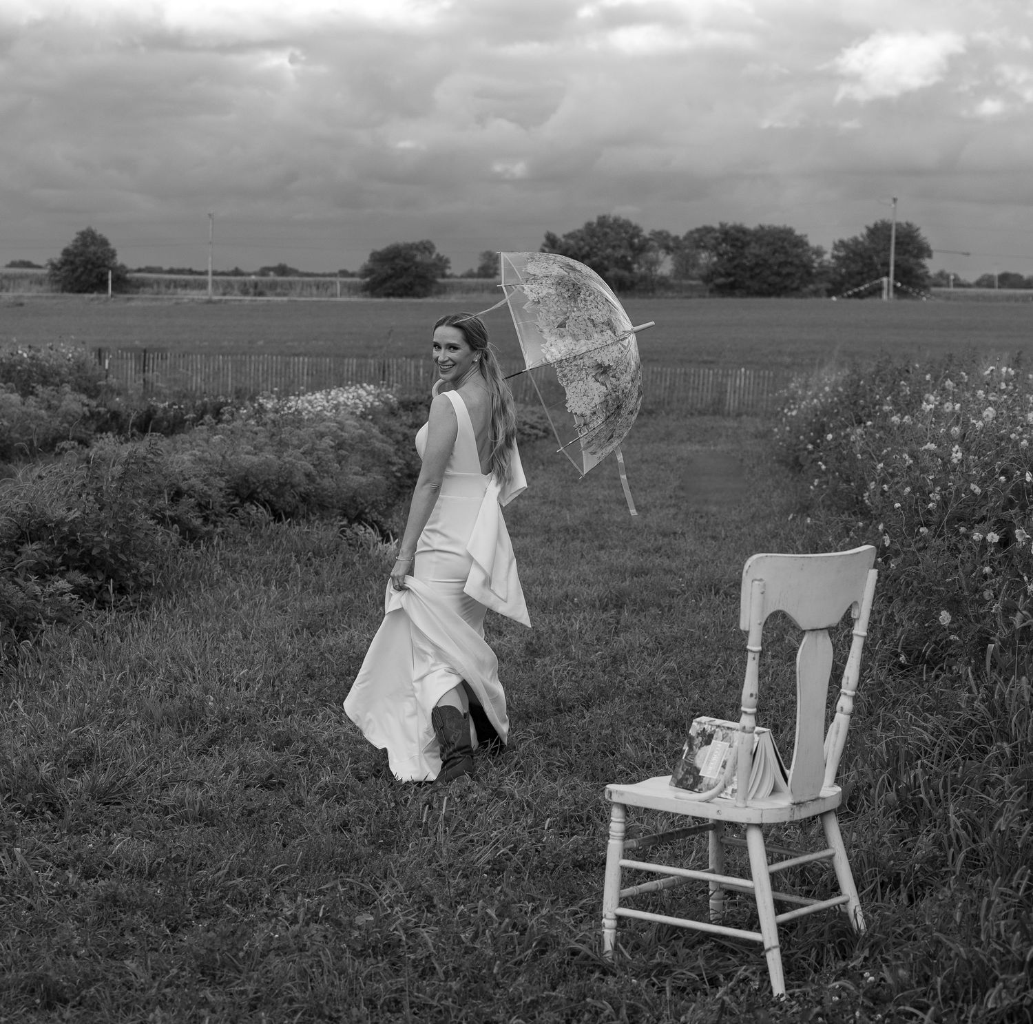 Vintage white chair placed in field of wildflowers for wedding photography.