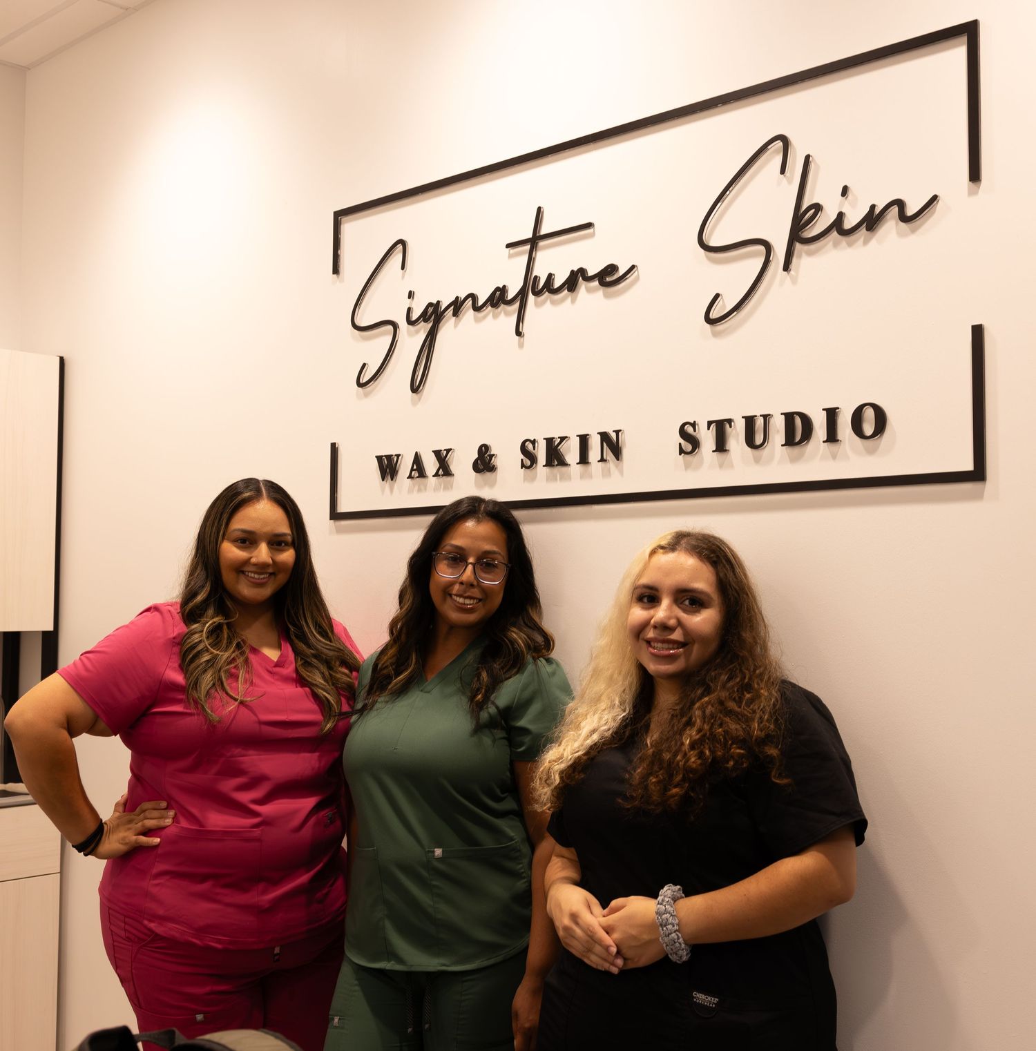 Interior view of a wax and skin studio with signage and staff members.