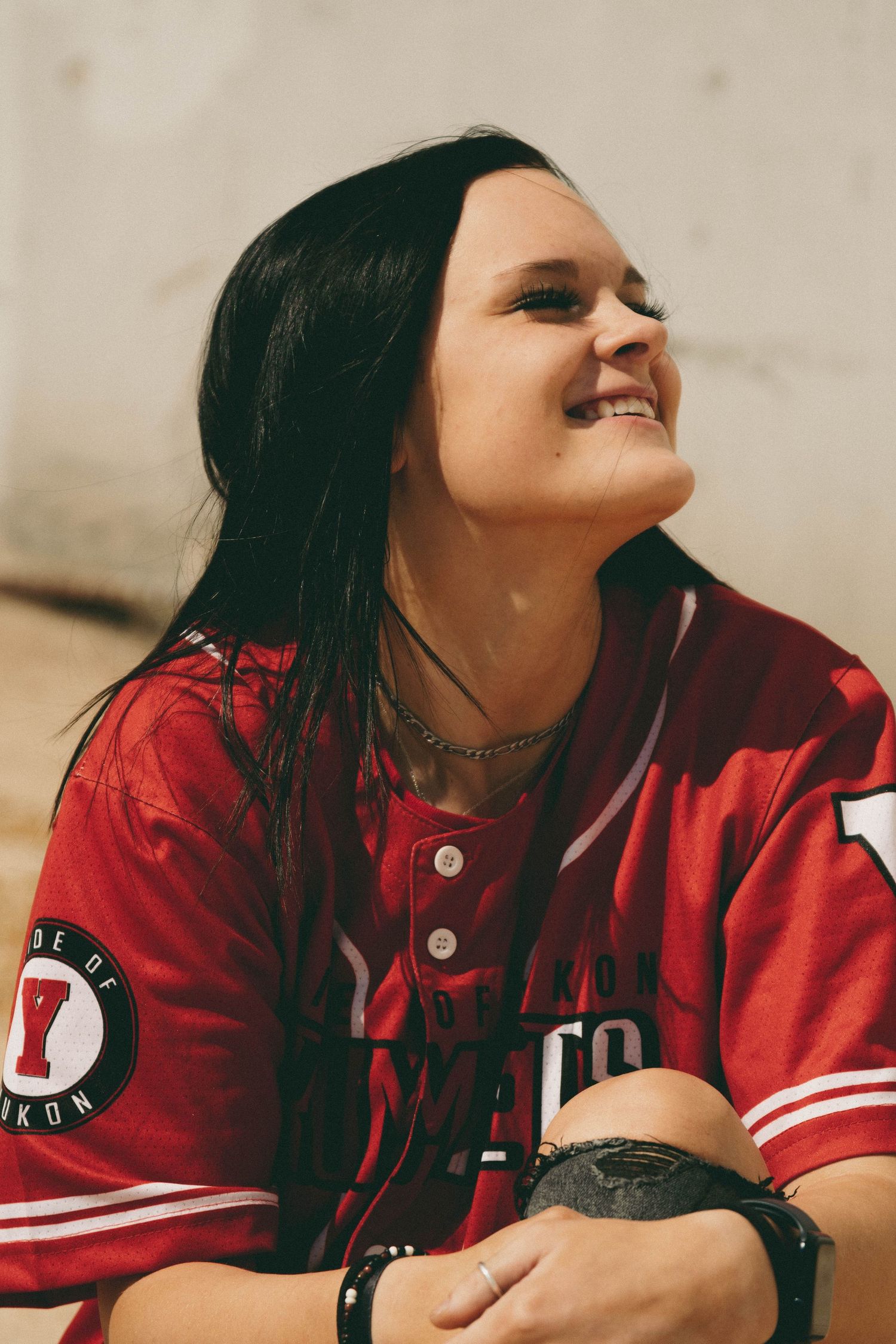 Person wearing red varsity jacket looking upward in a series of artistic portrait shots.