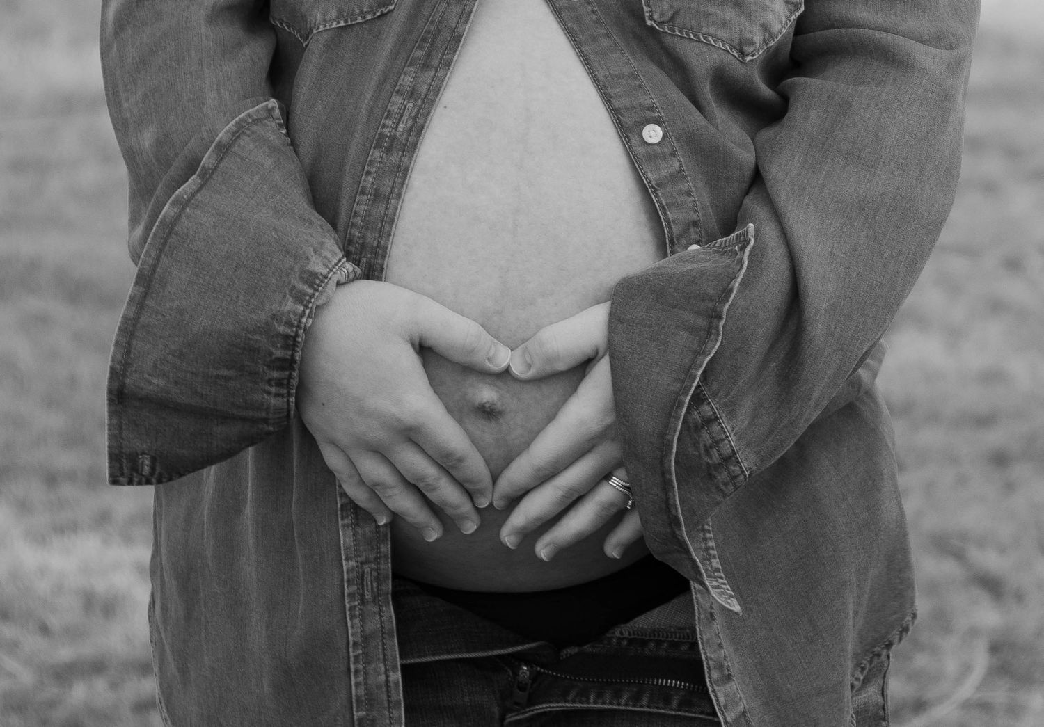Black and white series of close-up shots showing hands on pregnant belly.