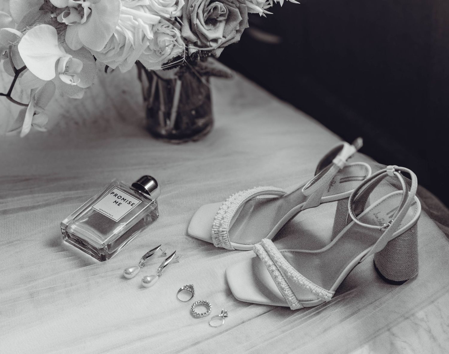 Still life arrangement of jewelry and accessories in black and white.