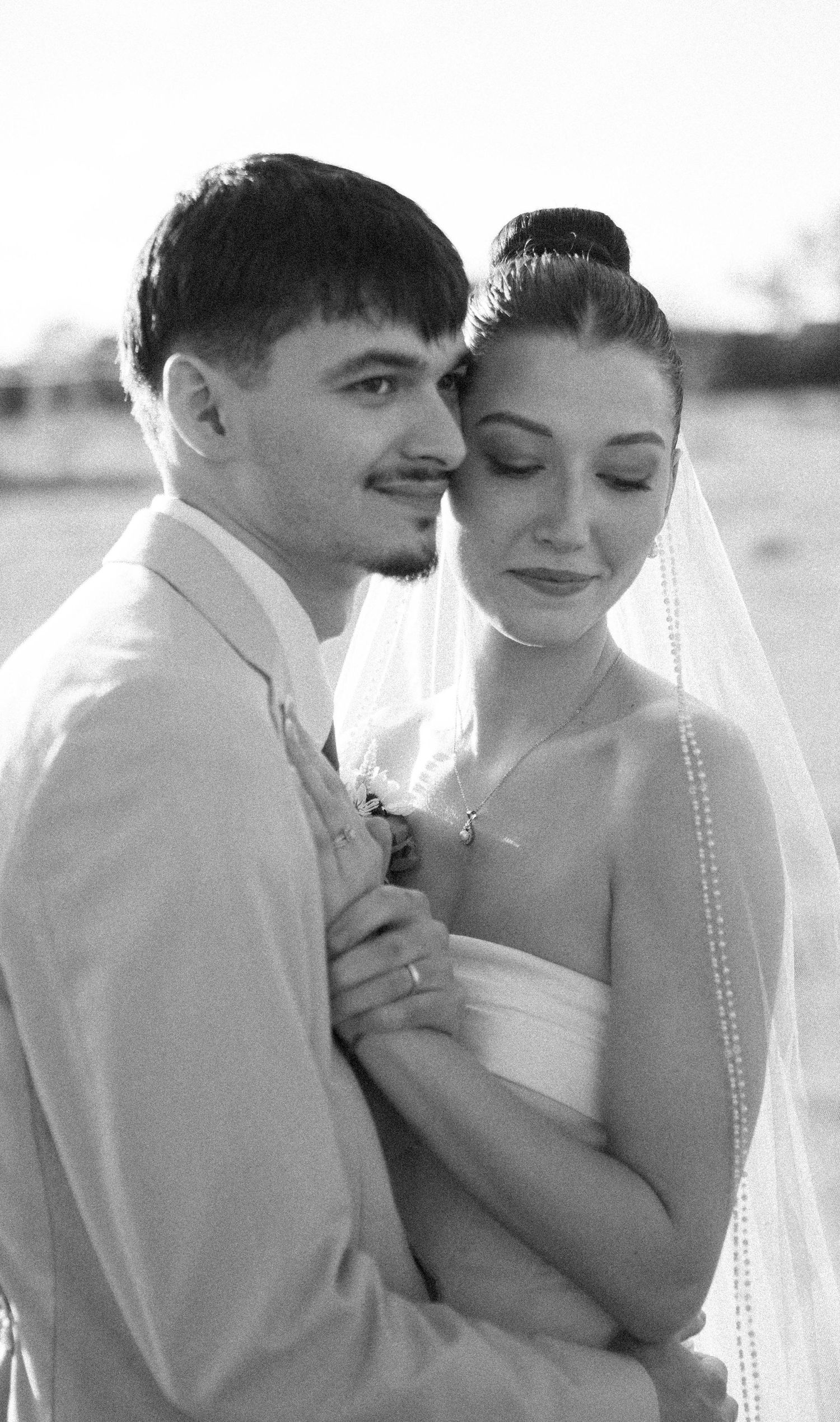 Intimate black and white portrait of newlyweds sharing a tender moment together.