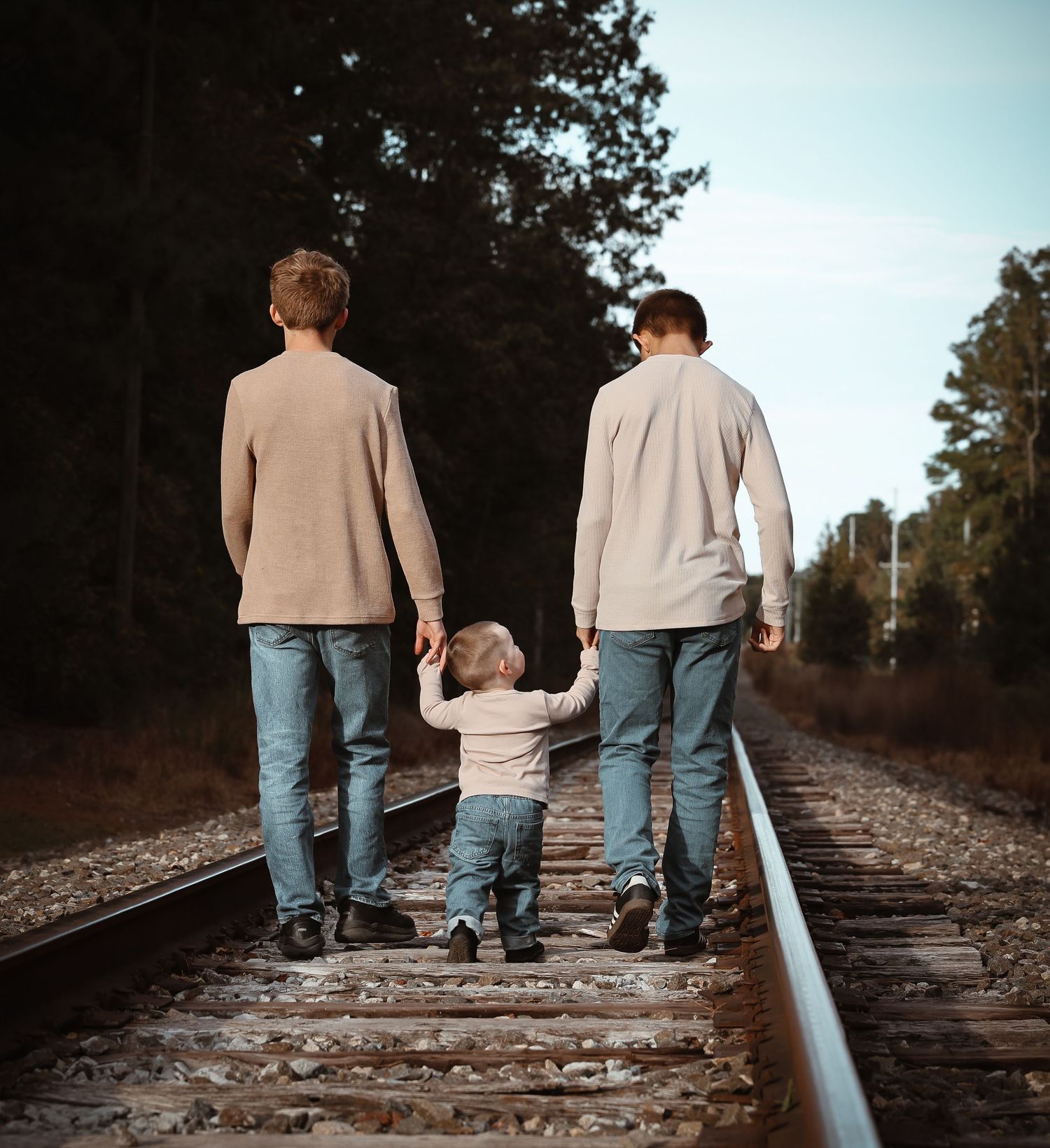 People walking together on railroad tracks captured from behind.