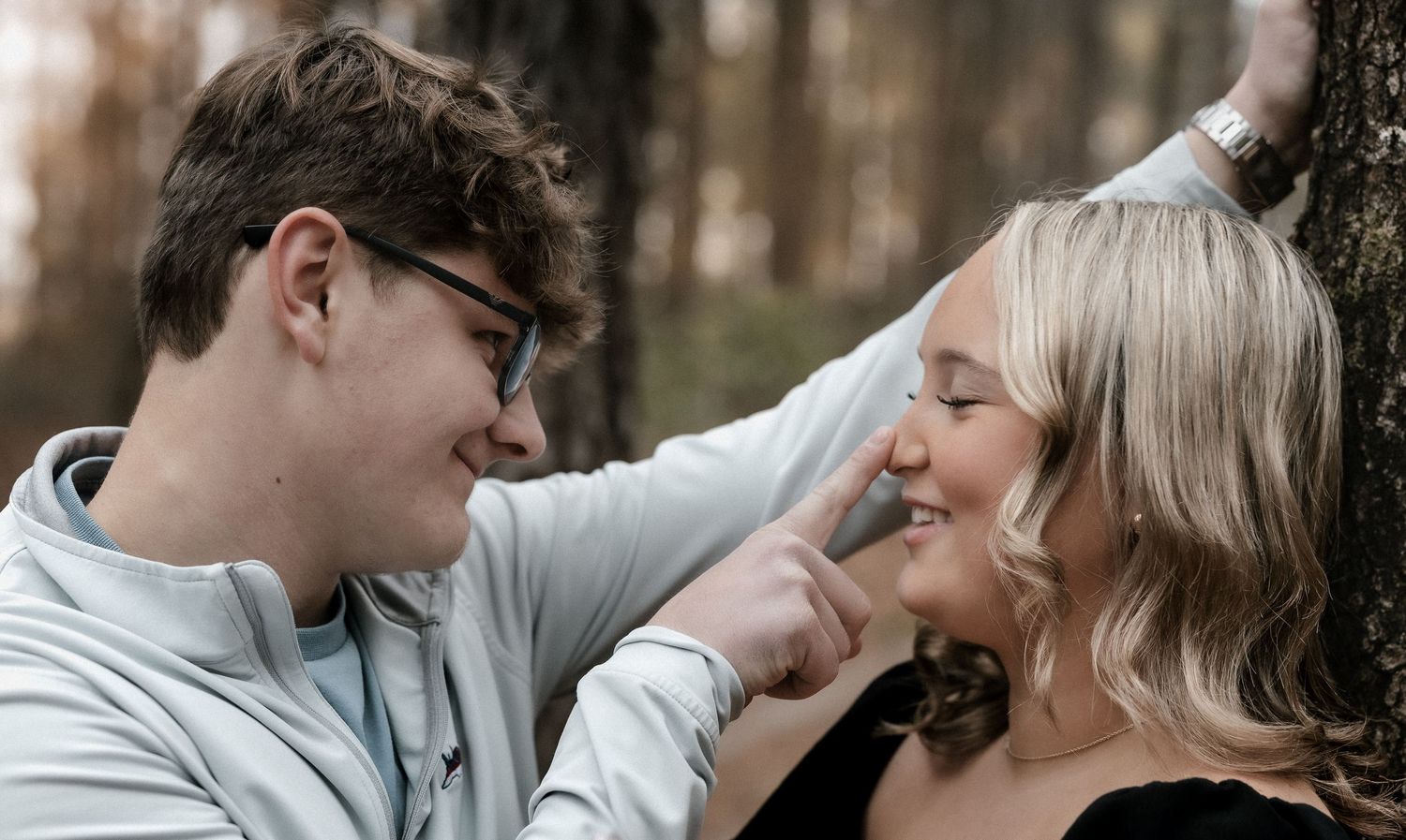 A couple shares romantic moments in a series of outdoor photos with a natural blurred background.