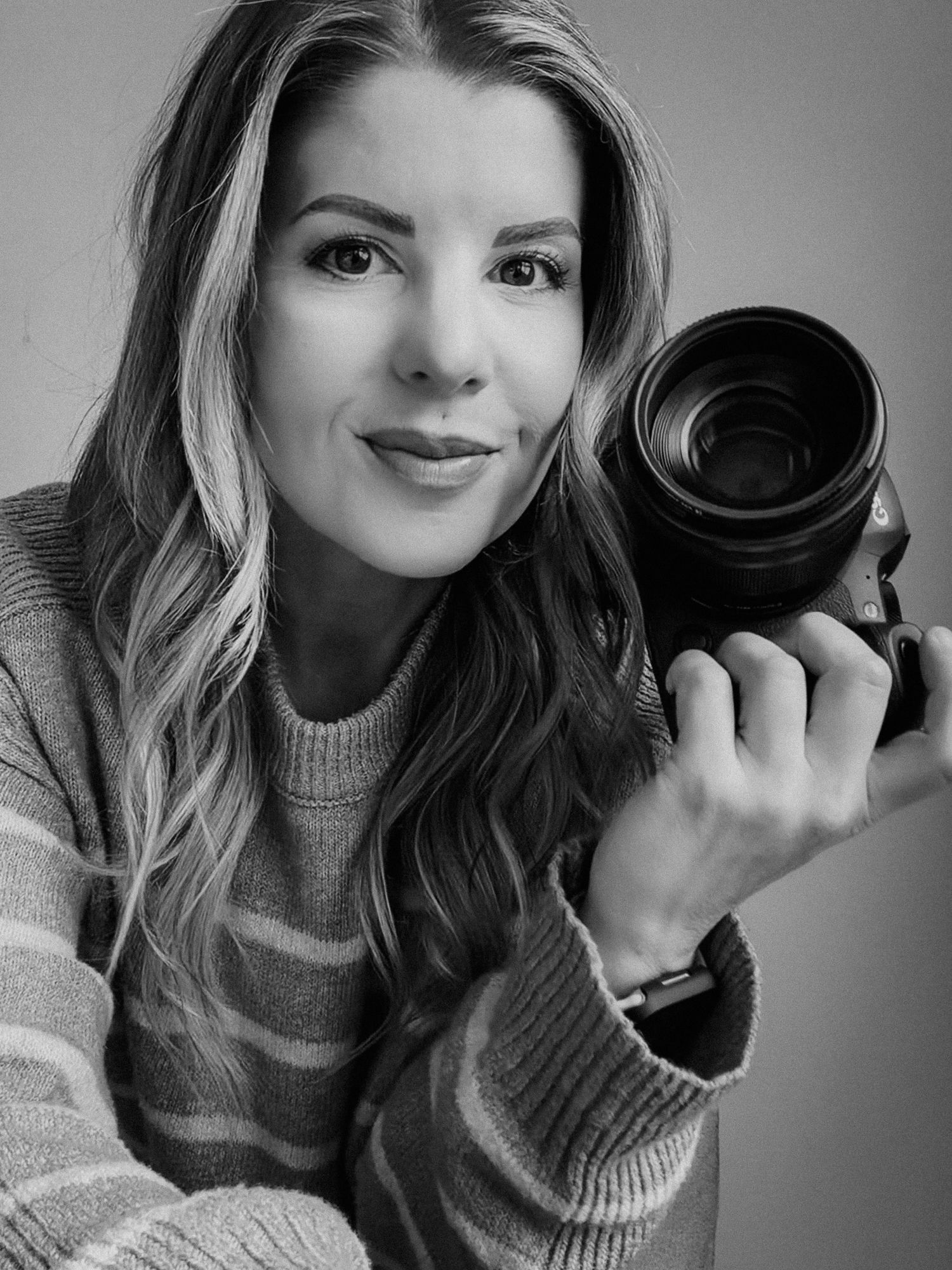 Black and white portraits showing playful poses with camera equipment.