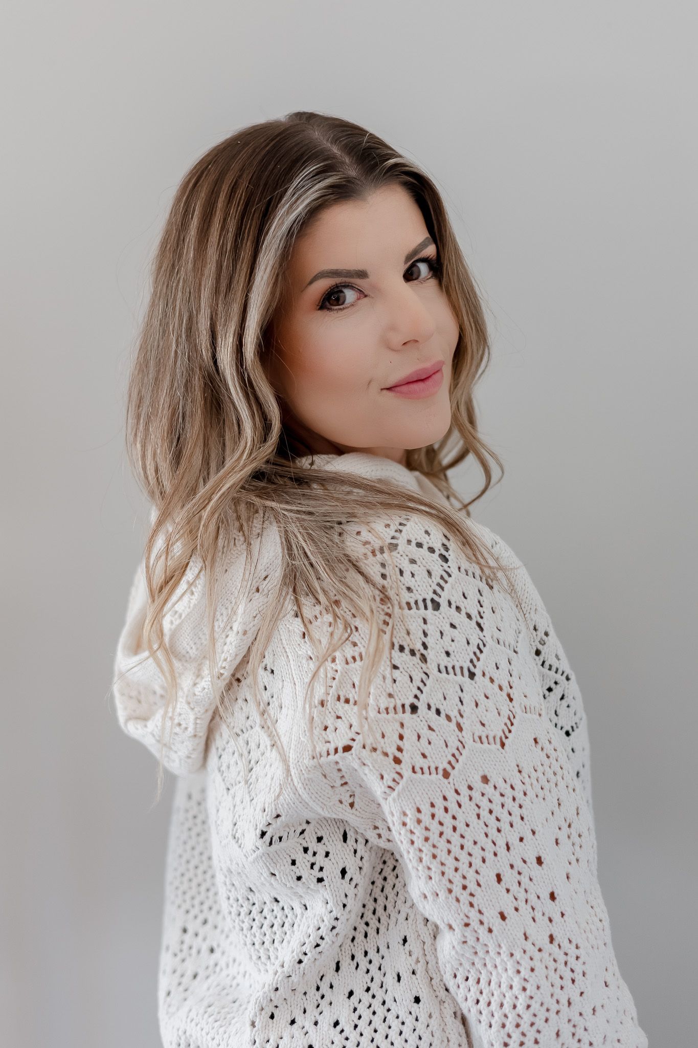 Portrait series in white lace sweater showing different poses against grey backdrop.