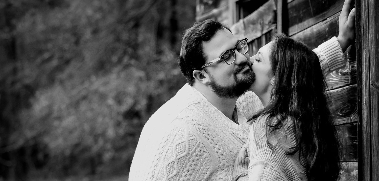 Black and white silhouettes of people embracing in an intimate outdoor photoshoot.