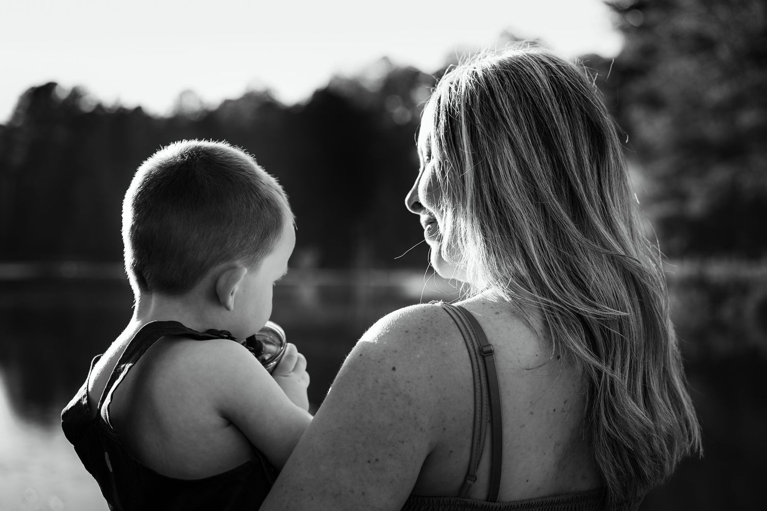 Silhouettes of people standing together against a dark background in black and white.