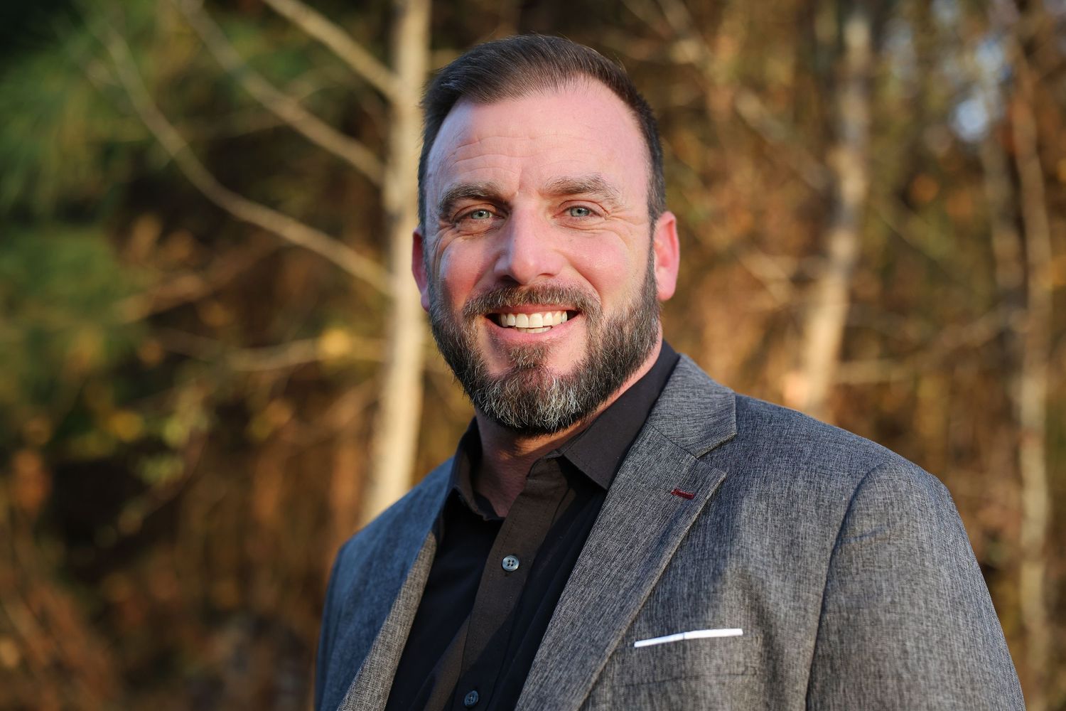 Professional headshot sequence outdoors with natural lighting and forest background.