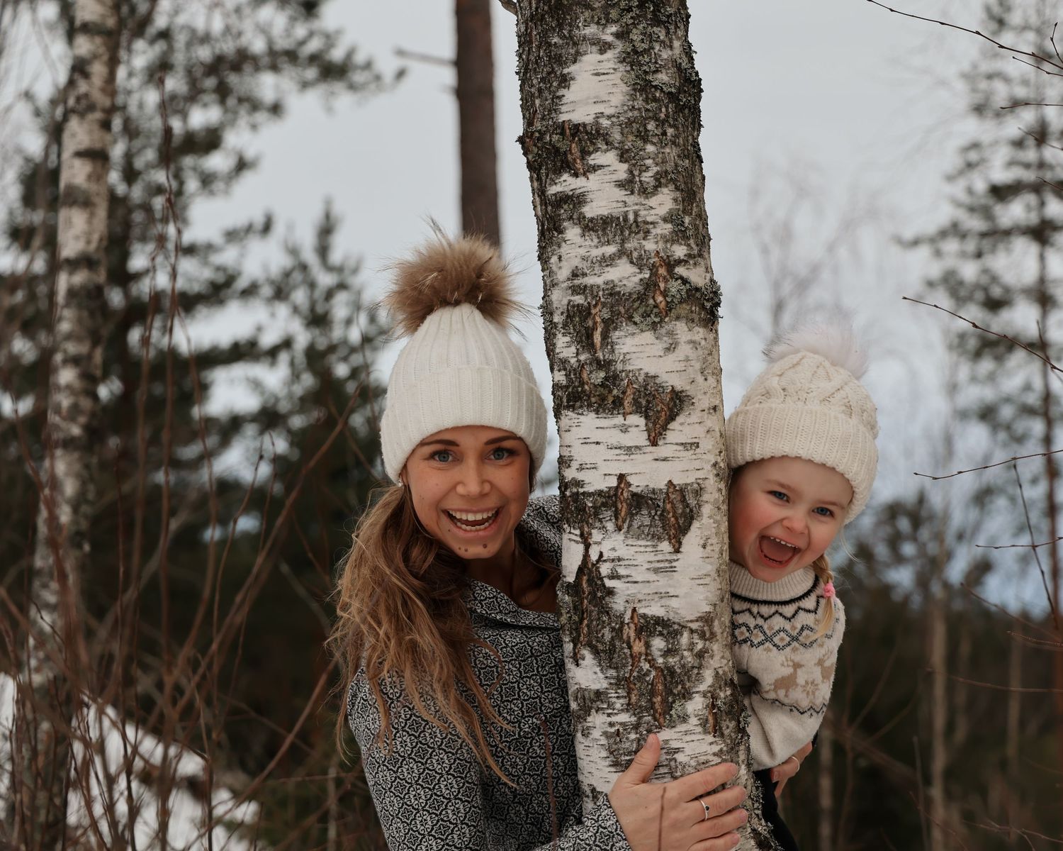 Familjefotografering - en mamma och en liten flicka i den snötäckta skogen i Jönköping